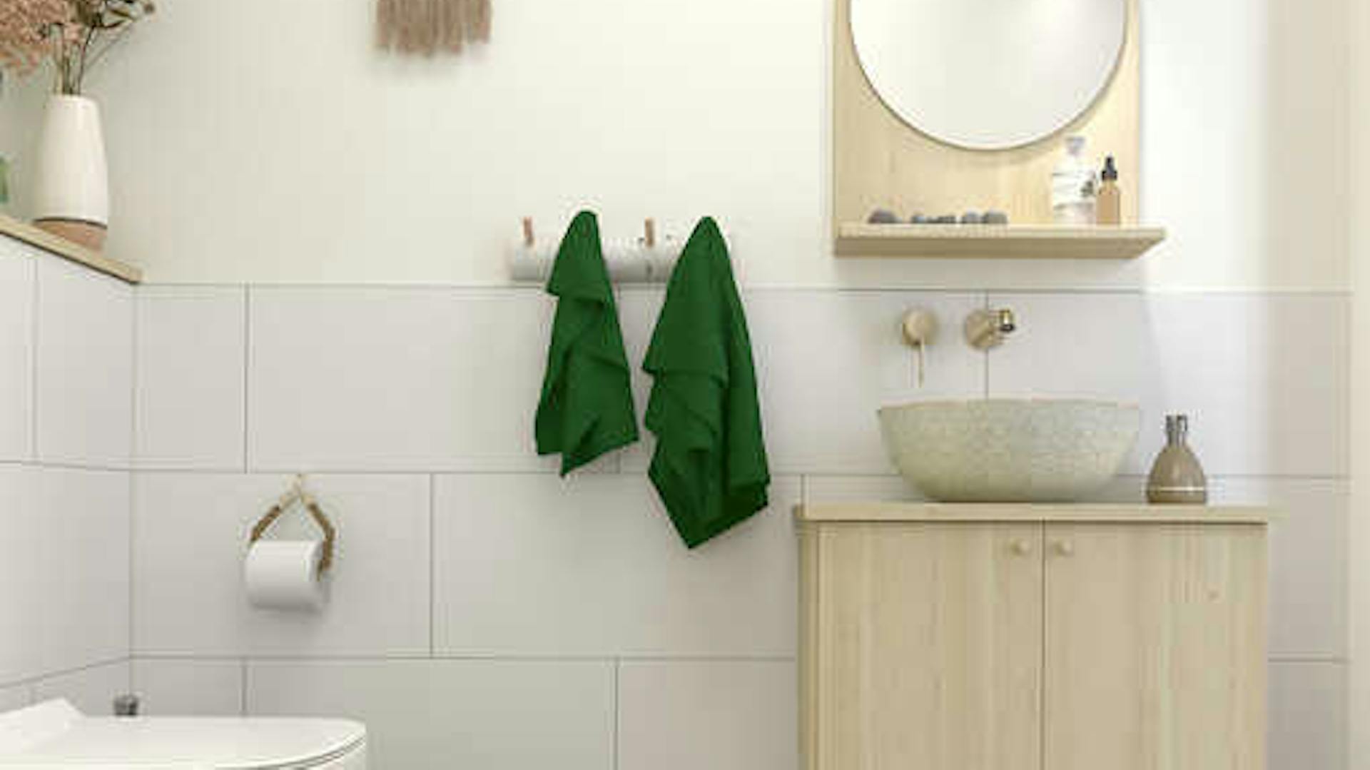 Ein warmes Bad mit einer Waschbeckenarmatur in Holzoptik und daneben eine Birkenstamm-Wandgarderobe als Handtuchhalter.