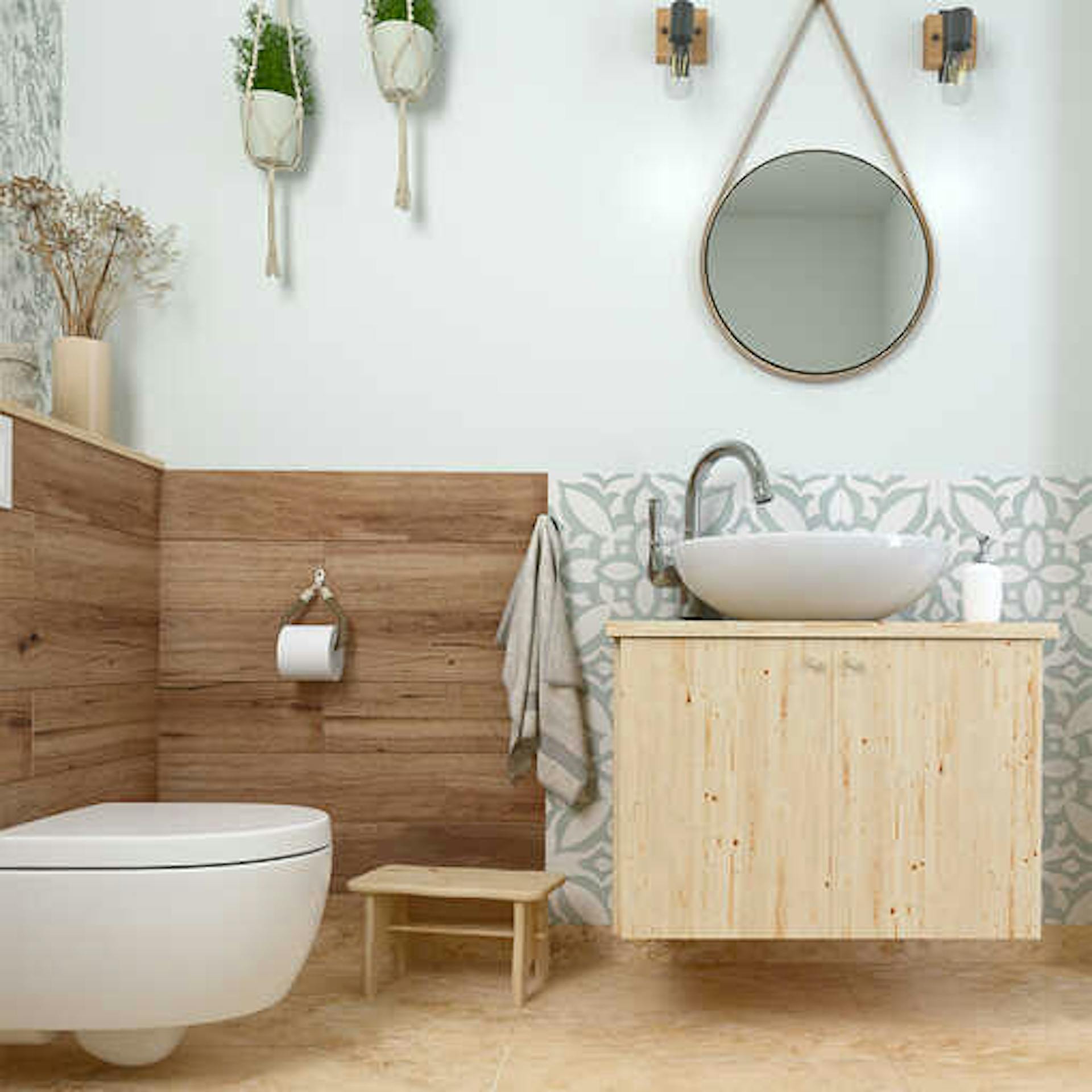 Ein warmes Bad mit einer dunklen Holzverkleidung an den Wänden und einer gemusterten Fliesenfläche hinter der Waschbeckenarmatur.