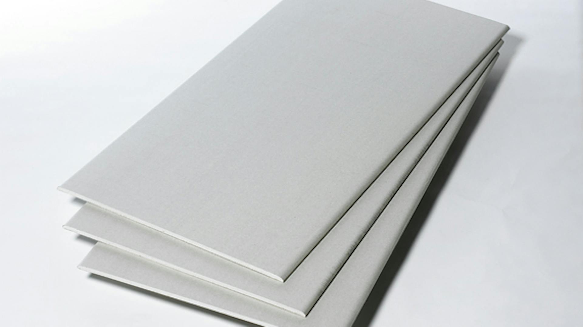 Drei weiße Gipskartonplatten liegen aufgefächert übereinander.