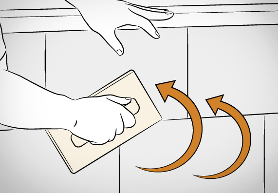 Kutil vyhlazuje obezdívku vany hladítkem.