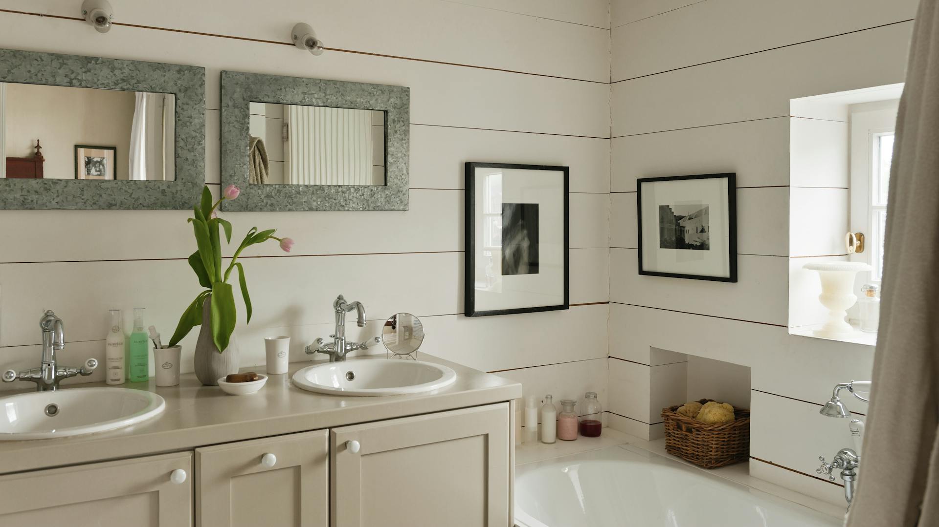 In einem Bad hängen zwei Bilder an der Wand.