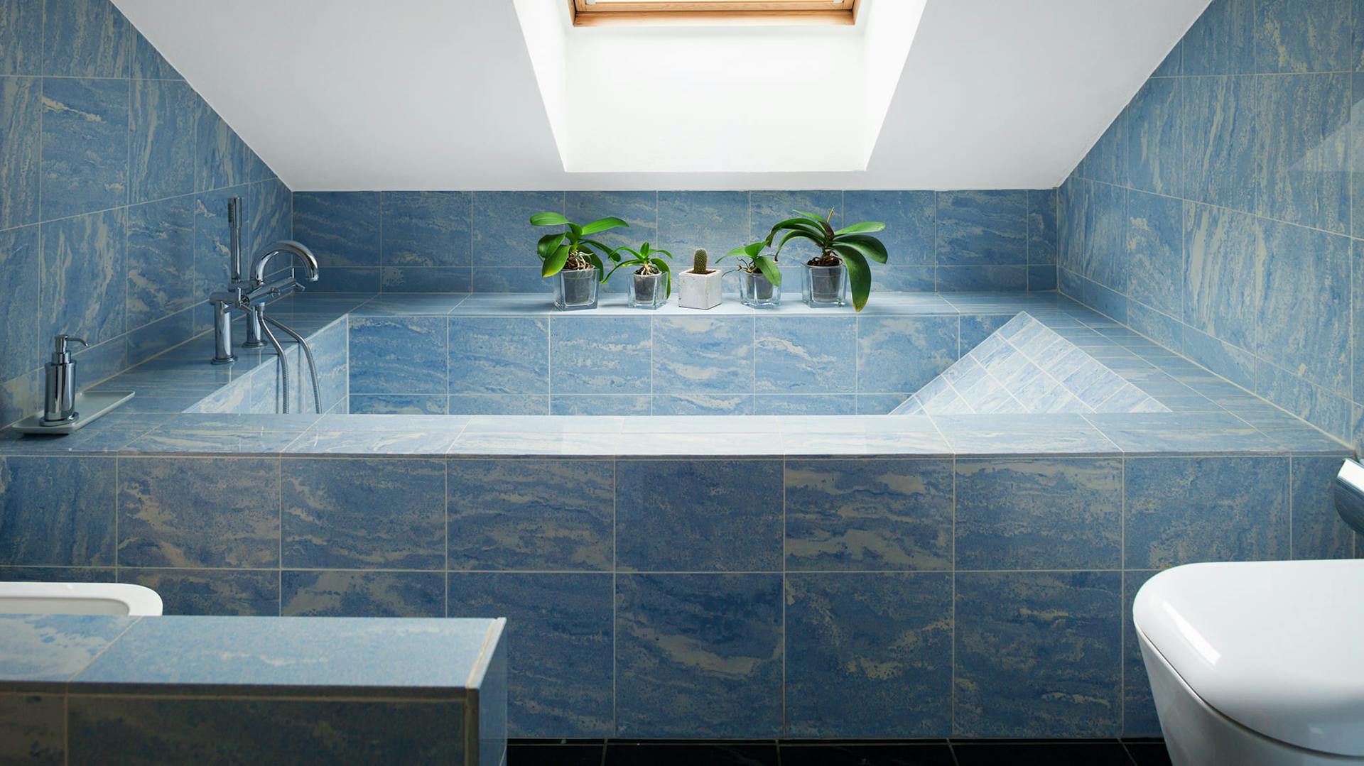 Bad mit gemusterten Fliesen in Blau.