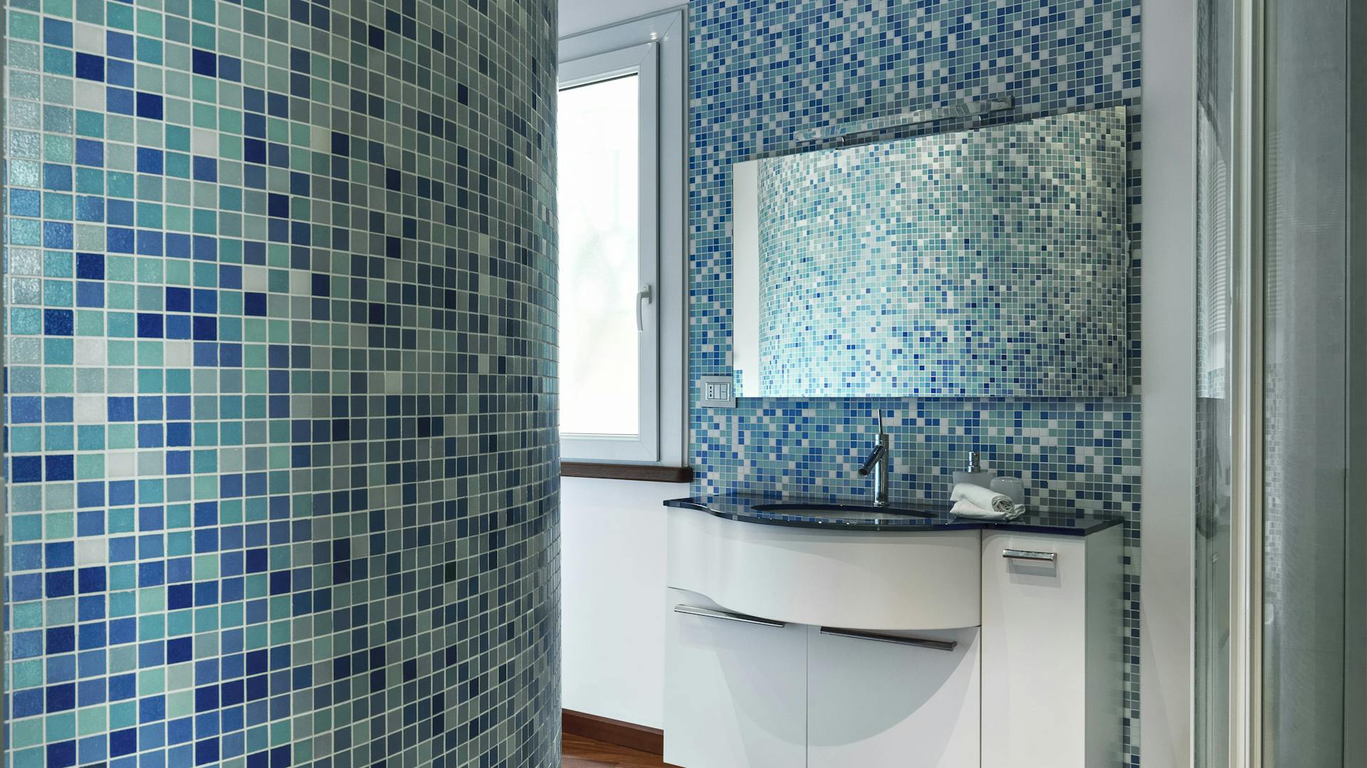 Badezimmer mit blauen Mosaikfliesen.
