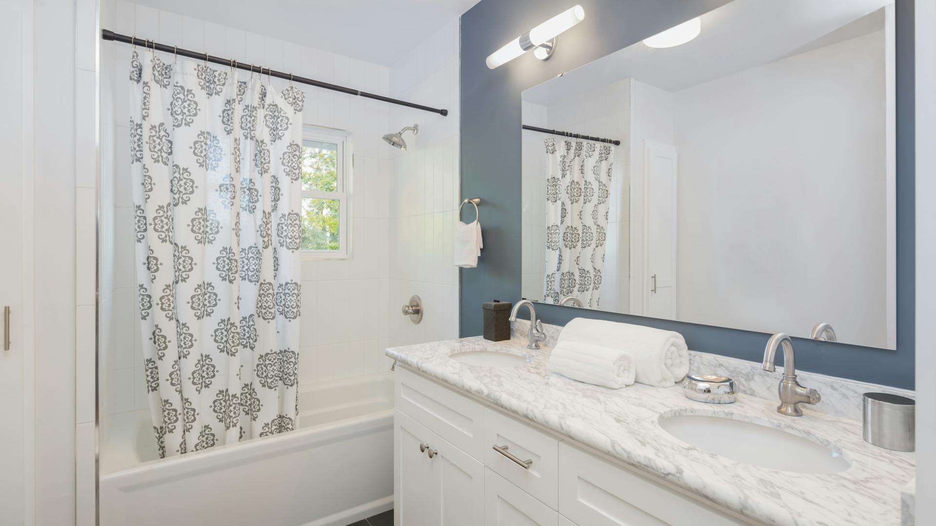 Ein weißes Badezimmer mit einer blauen Wand.