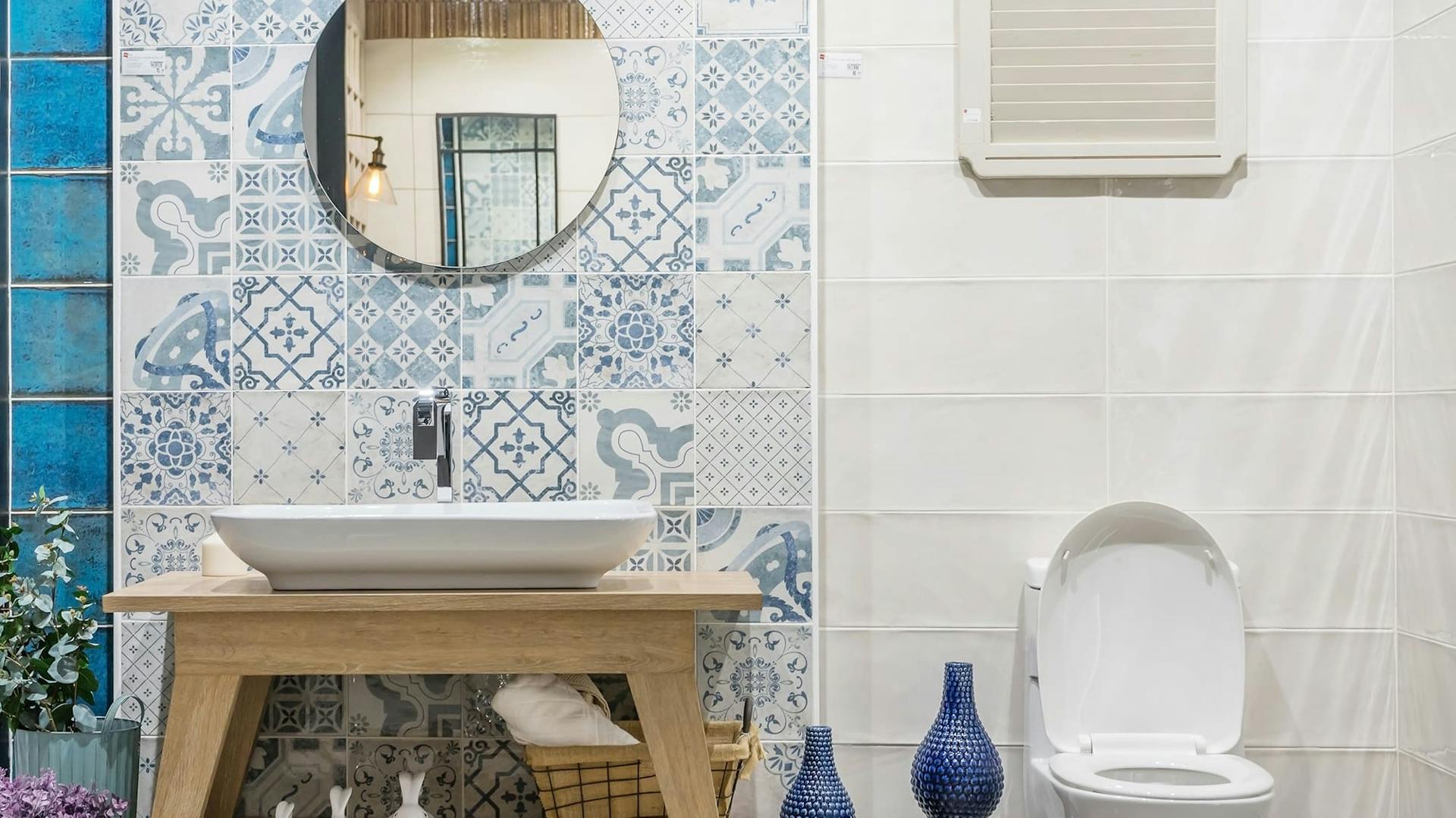 Badezimmer mit weißen Fliesen und blauen Mustern.