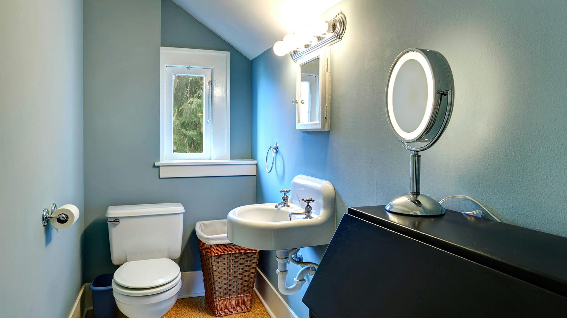 Badezimmer mit einer gräulich blauen Wandfarbe.