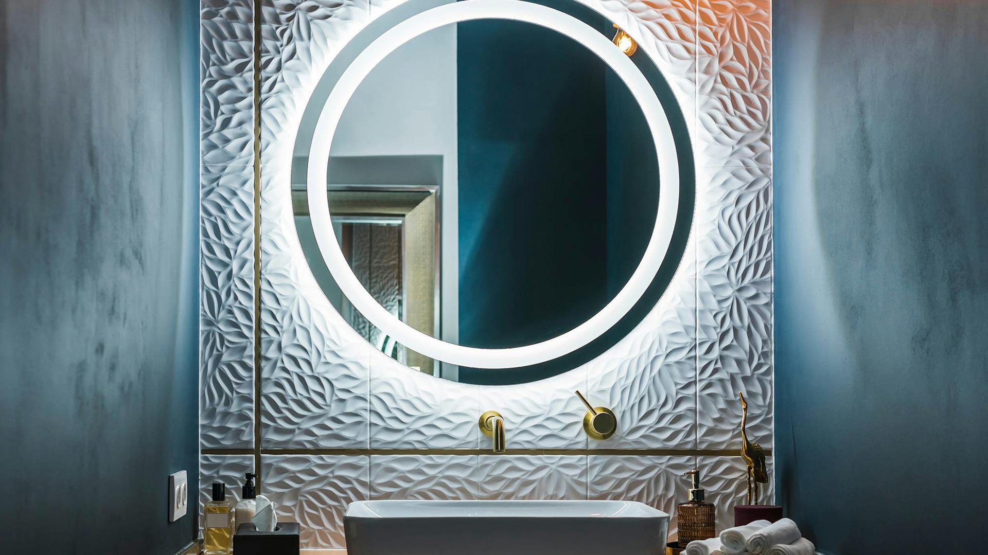 Ein Spiegel zwischen zwei grau-blauen-Wänden.