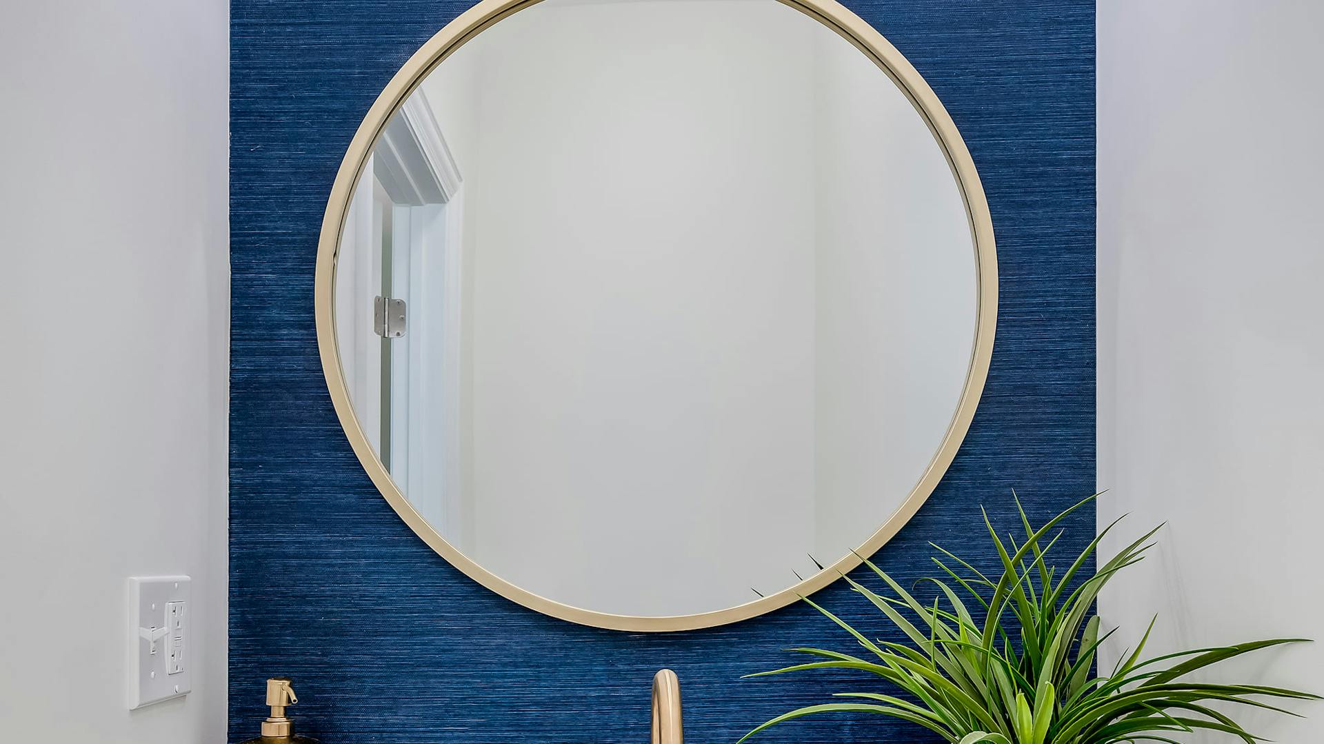 Spiegel hängt an einer blauen Wand.