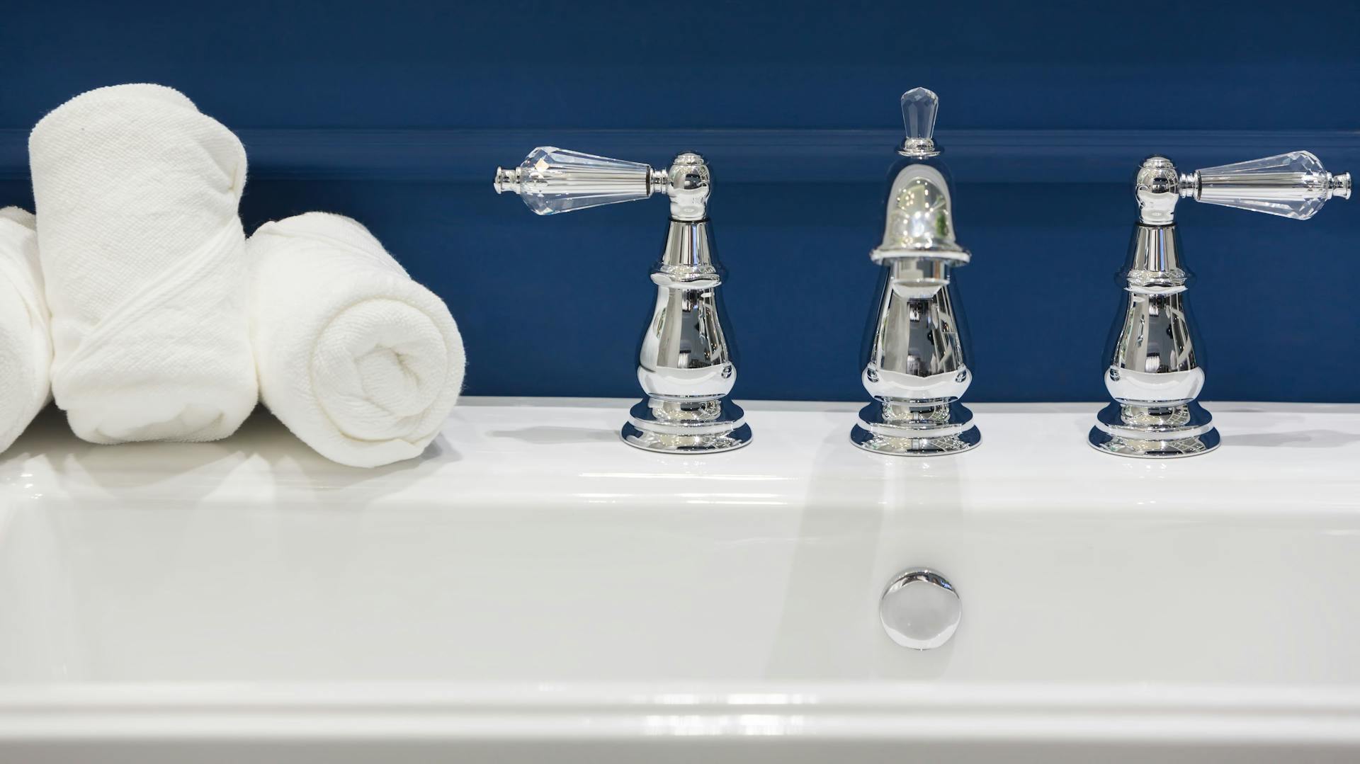 Ein weißes Becken vor einer blauen Wand.