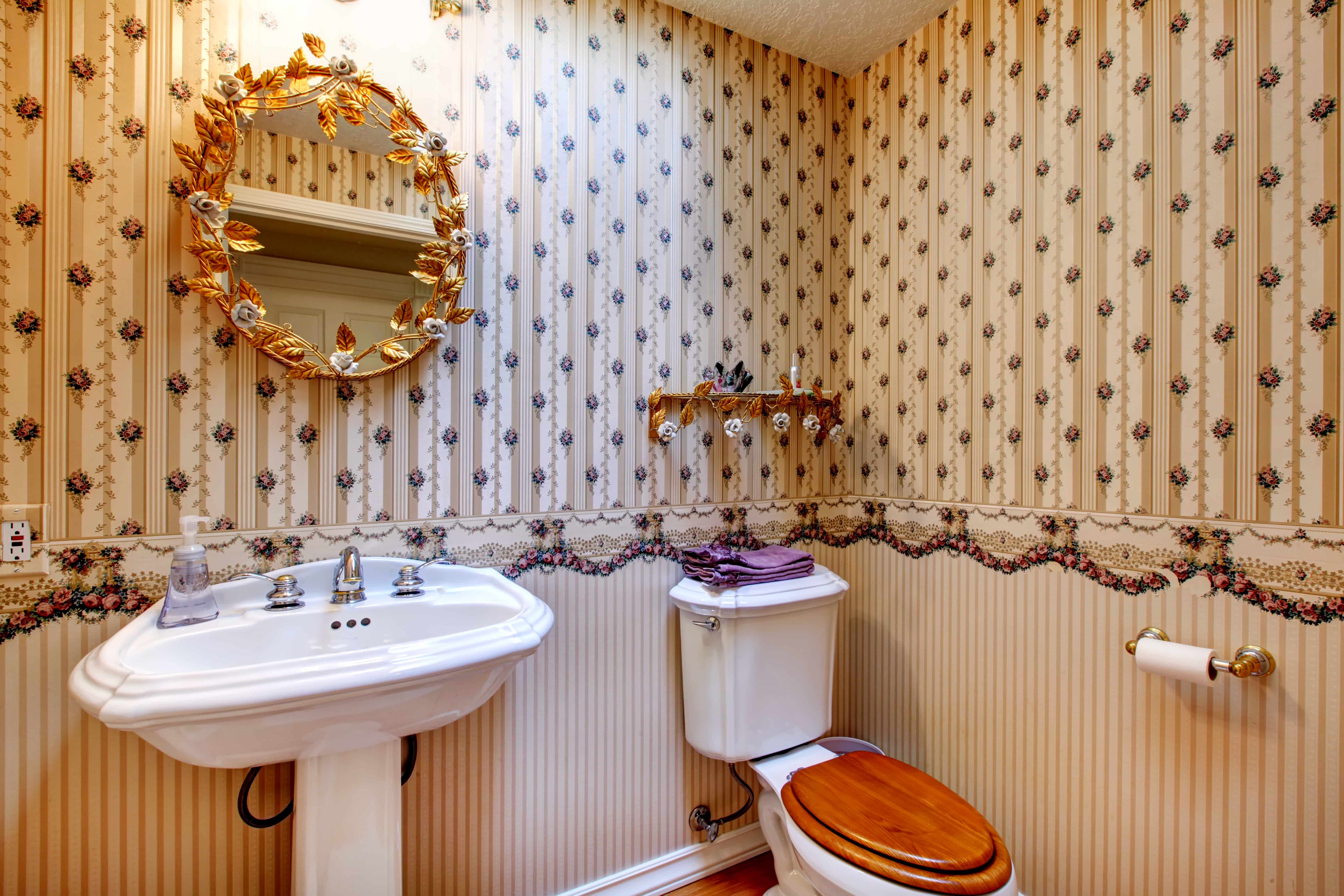 Badezimmer mit goldenem Spiegel.