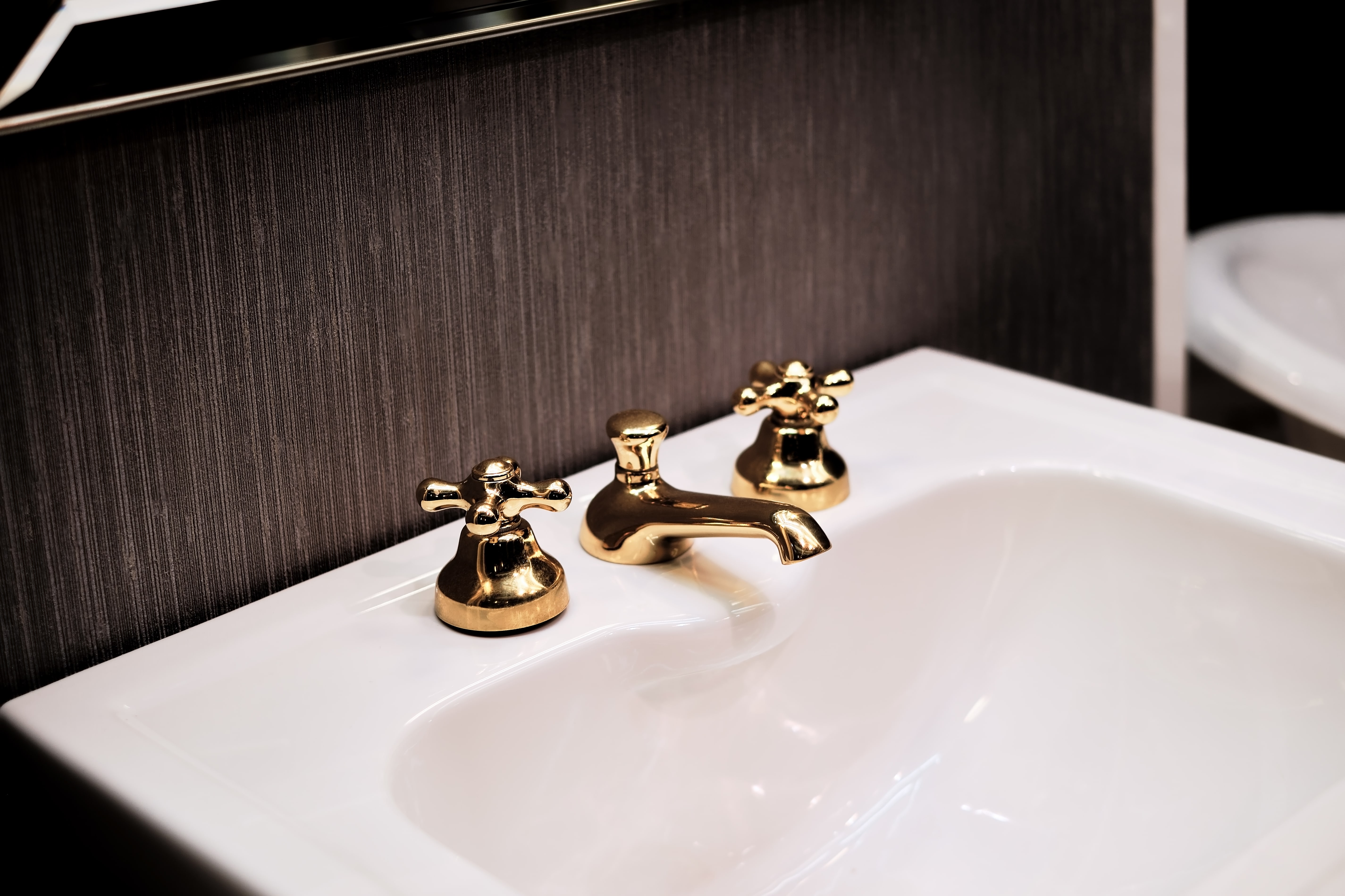 Waschbecken mit goldenem Wasserhahn.