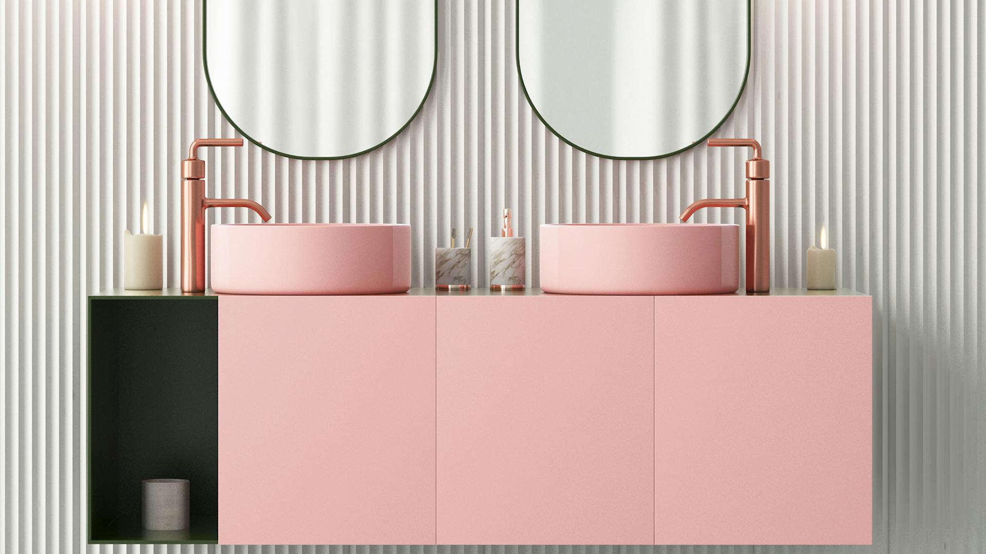 Lavabo doppio rosa con accento laterale nero. Sopra ci sono due specchi ovali.