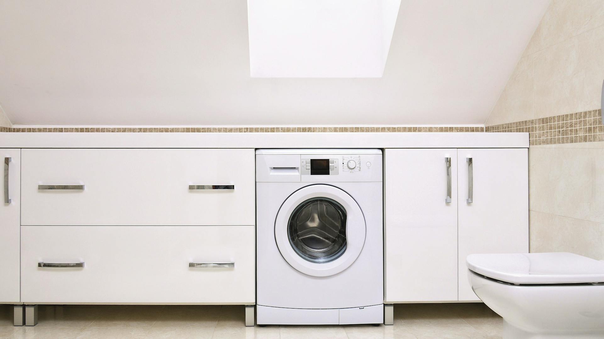 Bad mit Dachschräge bietet Platz für Waschmaschine und Stauraum.