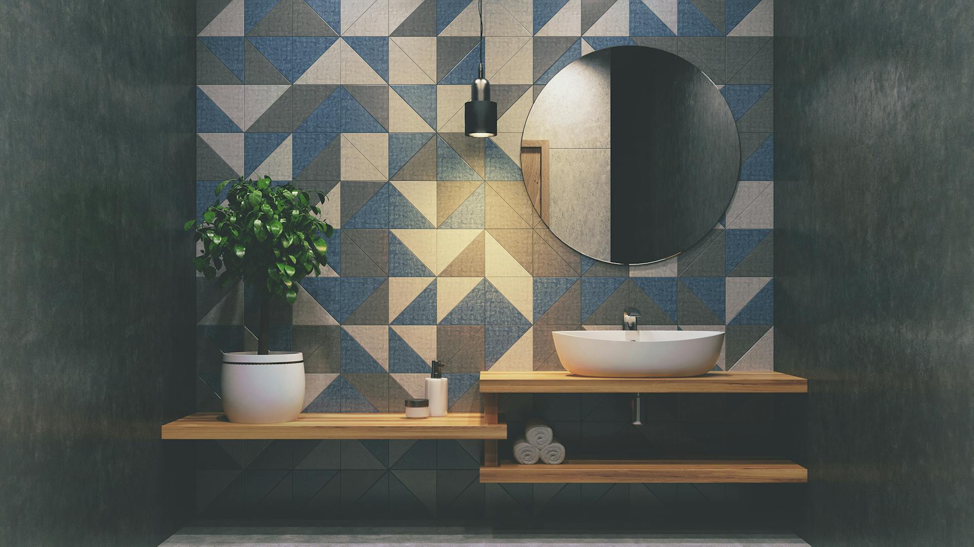 Bagno con piastrelle grigie, bianche e blu e lavabo in legno.