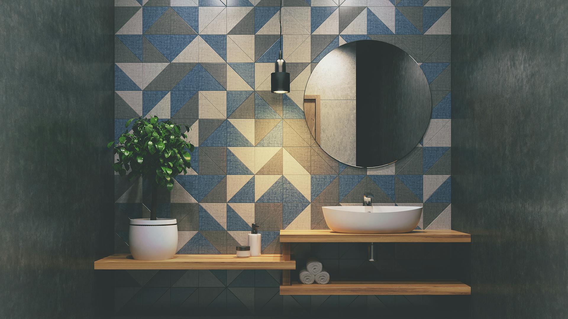 Koupelna s šedo-bílo-modrými obklady a dřevěnou deskou pod umyvadlo.