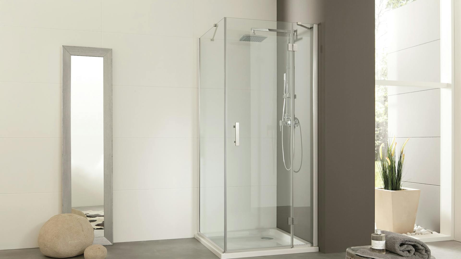 Fugenloses Bad mit Dusche und Spiegel.