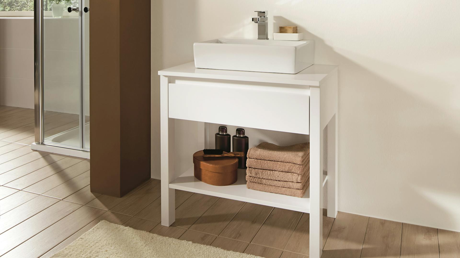 Natürliches Bad mit Waschtisch, Handtüchern und Holzboden.