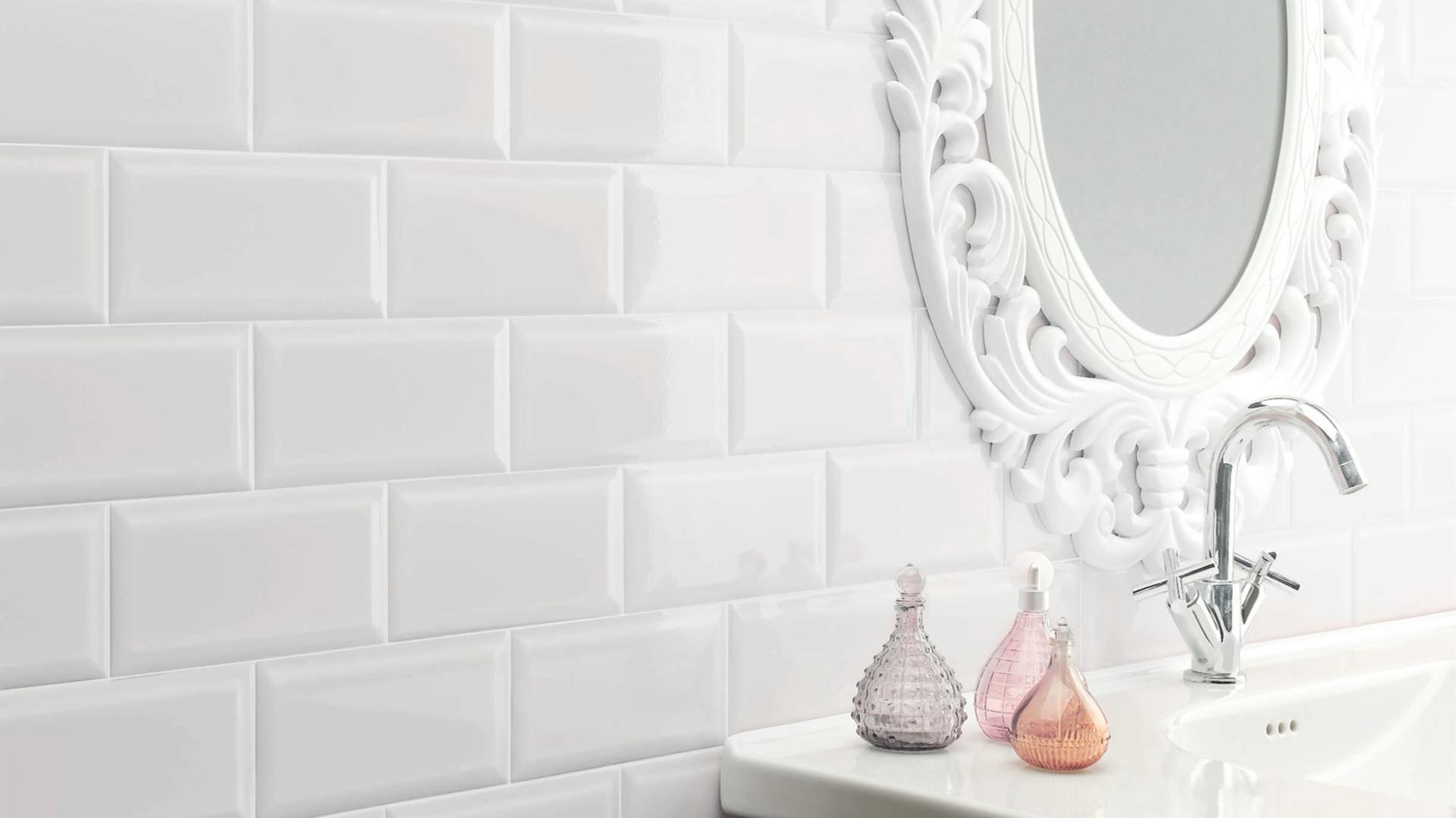 Klasické keramické bílé obdélníkové obkladačky za bílým umyvadlem.