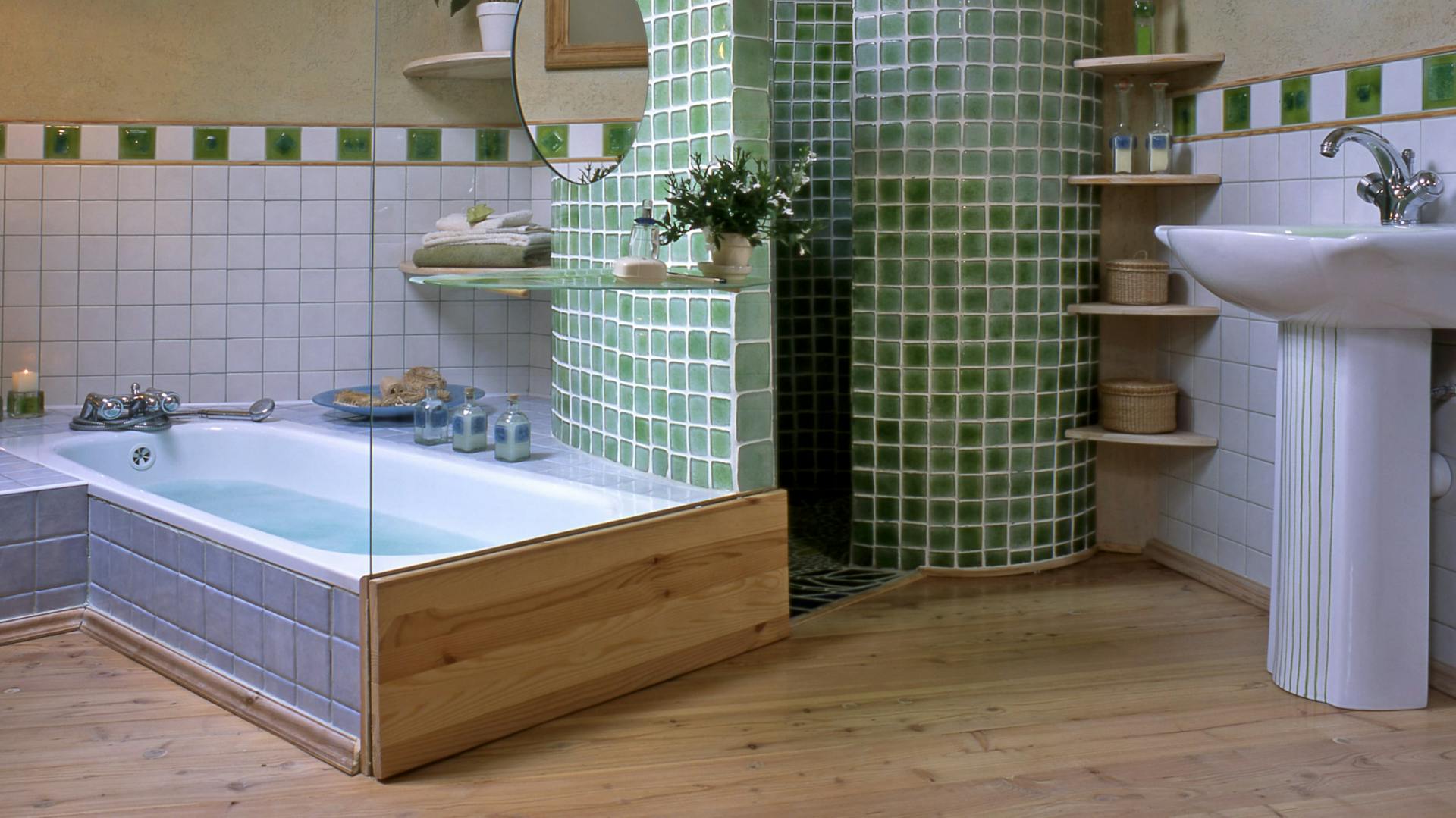 Badezimmer mit blauen und grünen Fliesen sowie einem Holzboden.