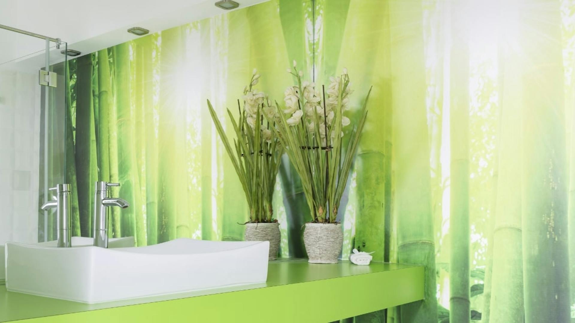 Badezimmer mit Naturmotiven auf der Wand.