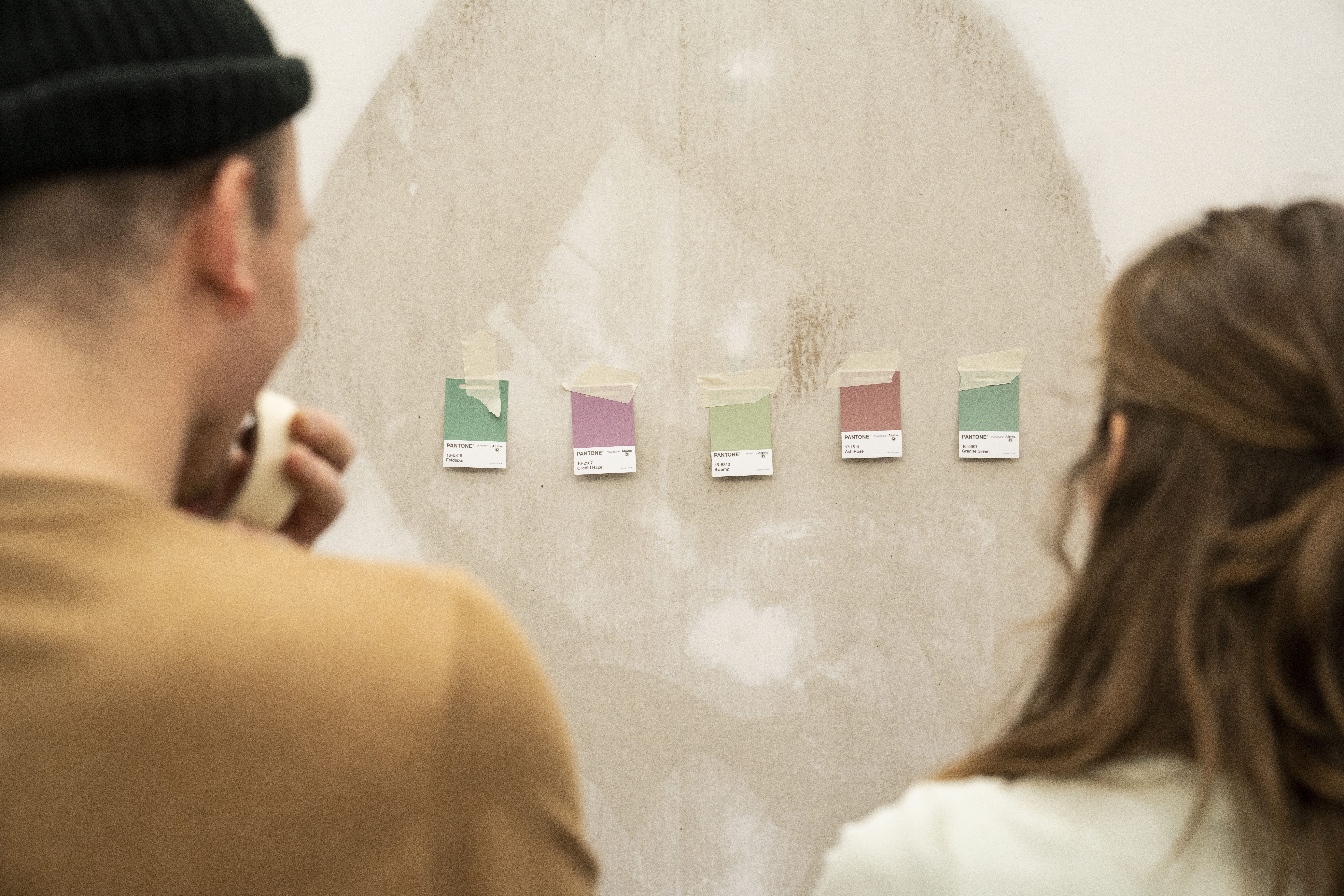 Degli artigiani davanti ad una parete con i campioni dei colori.