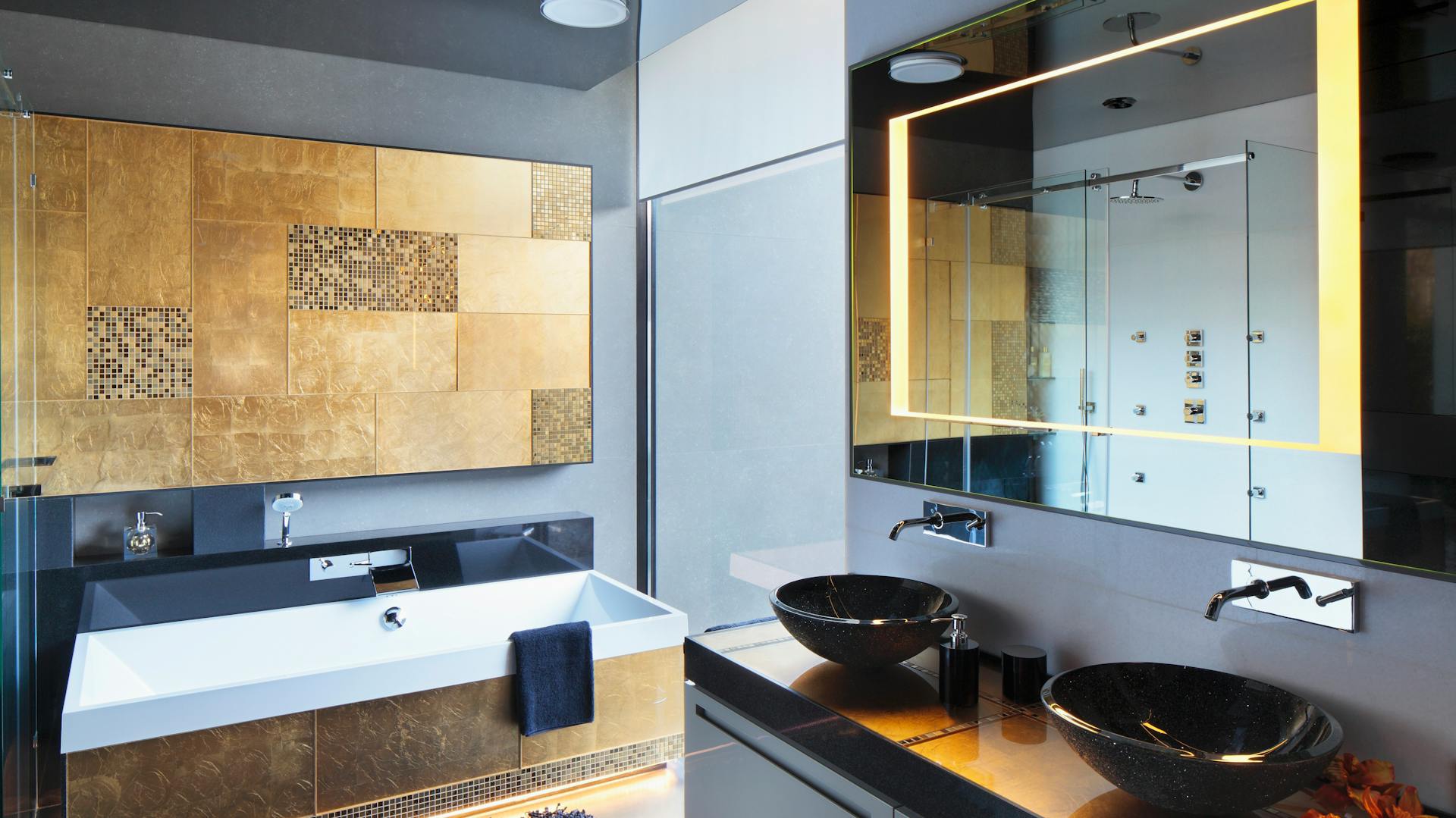 Bagno con vasca da bagno, lavabo e specchio con illuminazione.