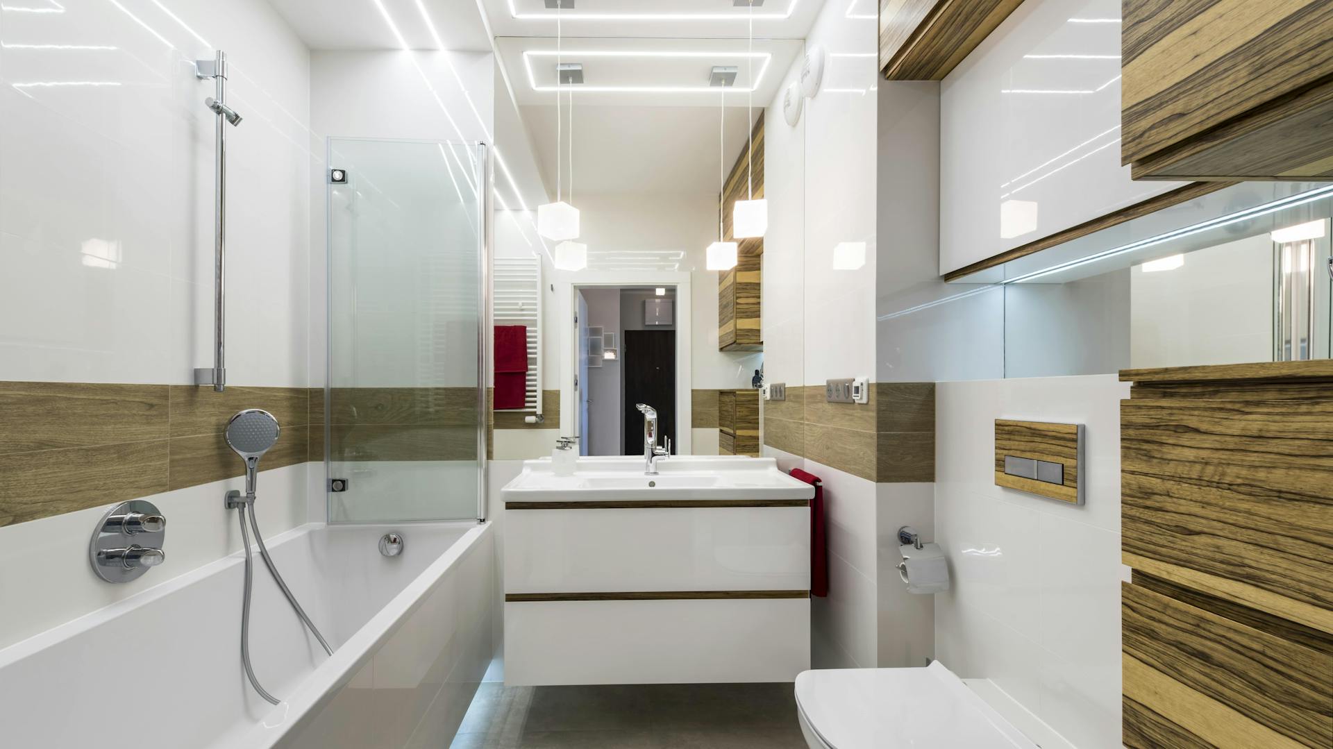 Bagno moderno con pannello luminoso e lampade a sospensione