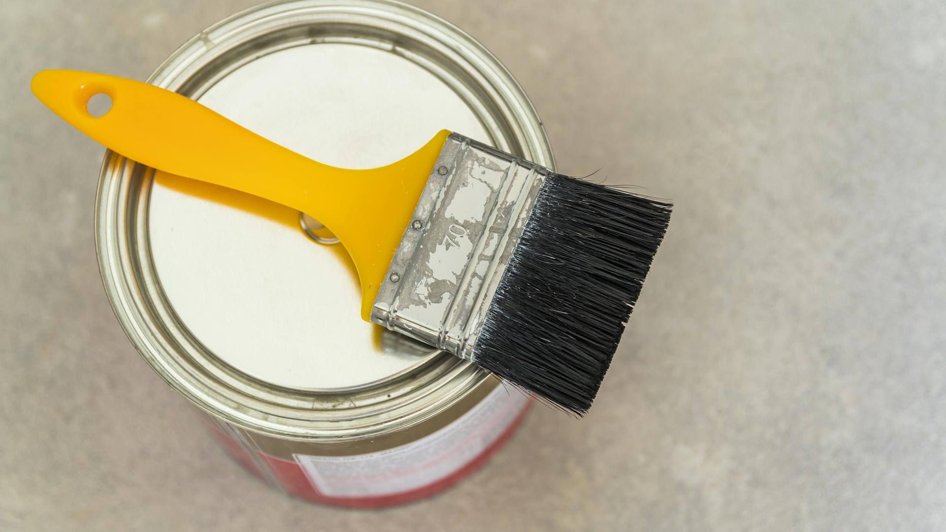 Ein Pinsel liegt auf einem Farbtopf.