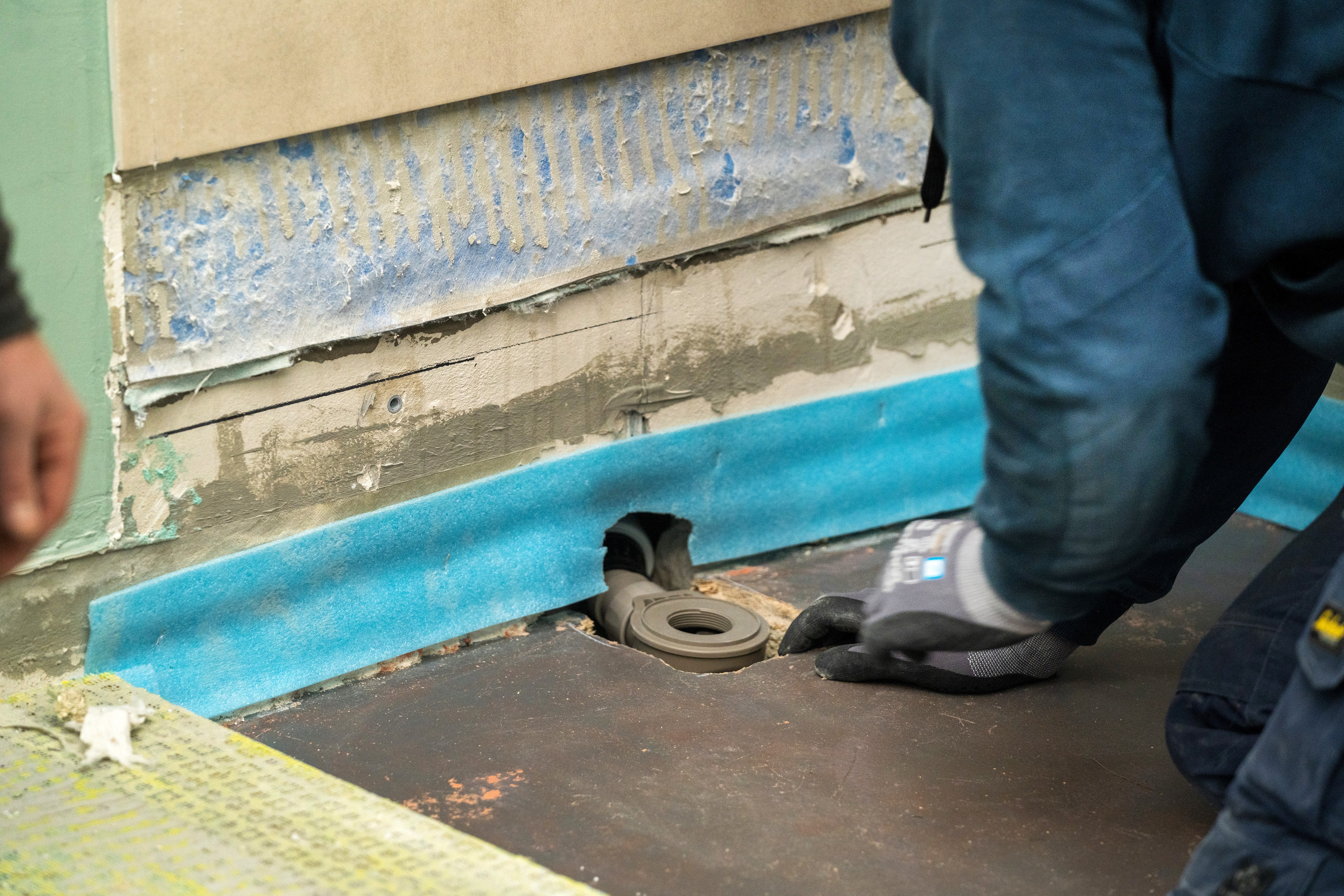 Egy barkácsoló burkolható zuhanytálcát szerel be.