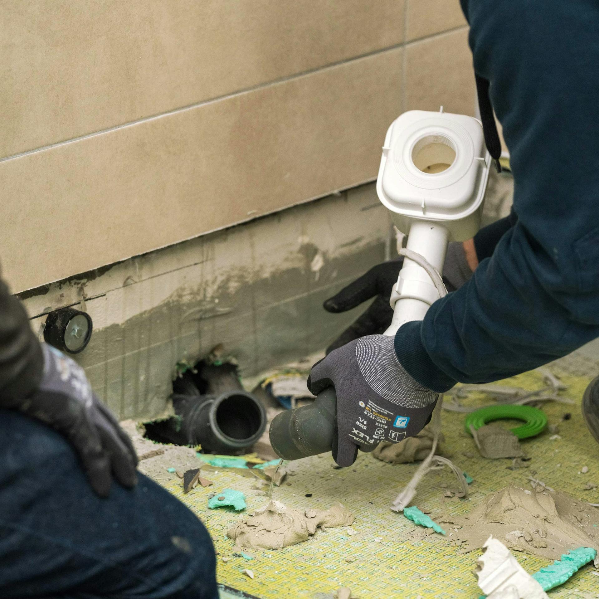 Valaki eltávolítja a régi zuhanyzó szifonját