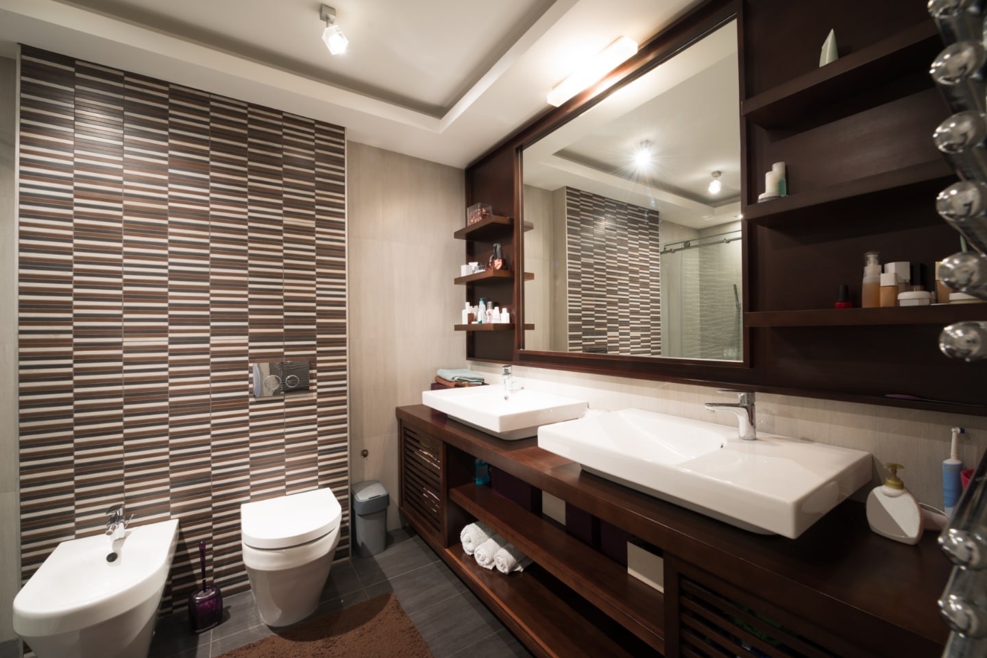 Badezimmer mit dunklen Badmöbeln aus Holz.