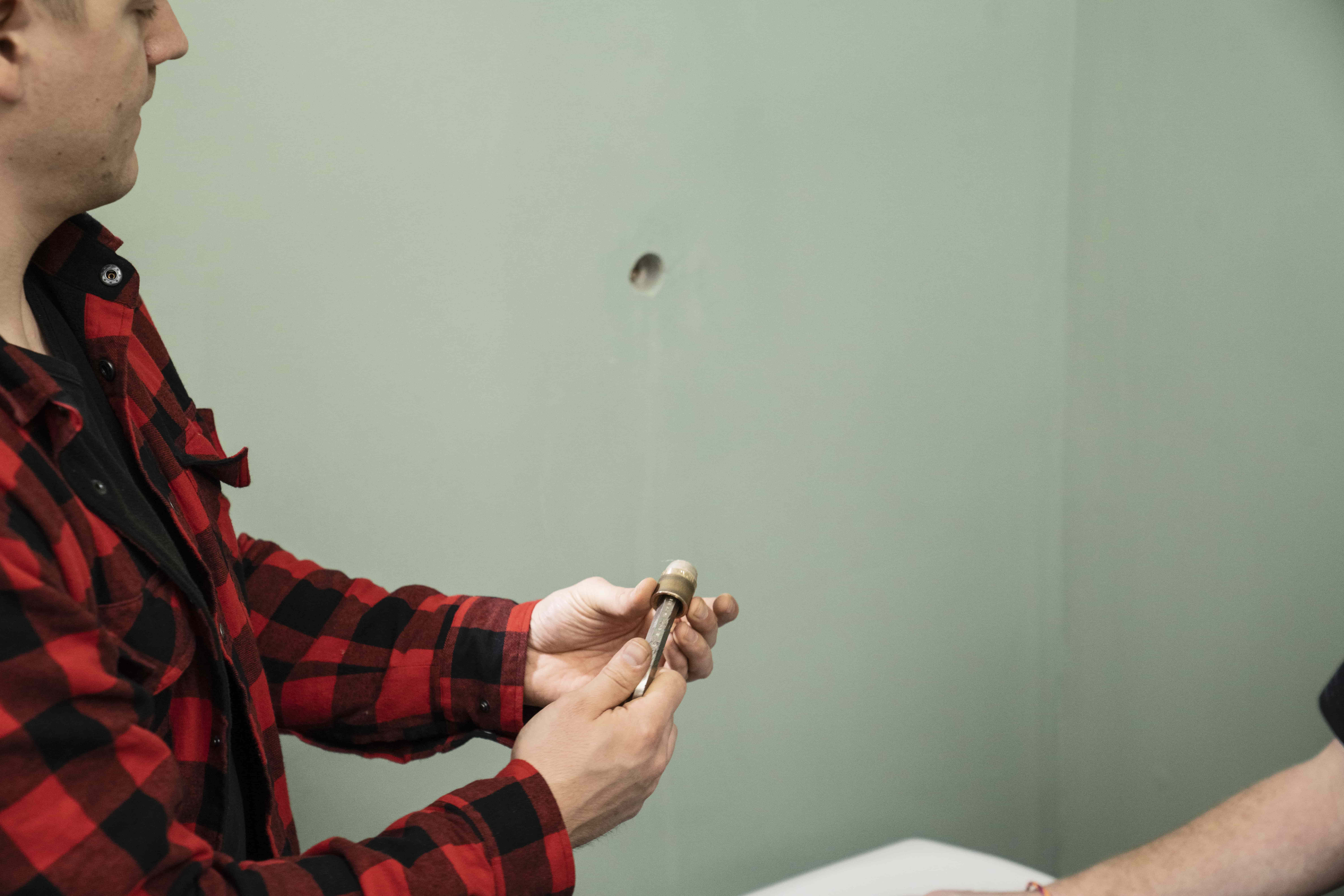 Ein Heimwerker hält ein Eckventil in seiner Hand.