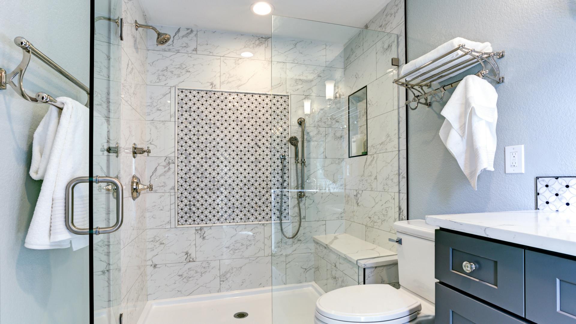 Ein weiß gefliestes Bad mit einer großen Dusche.