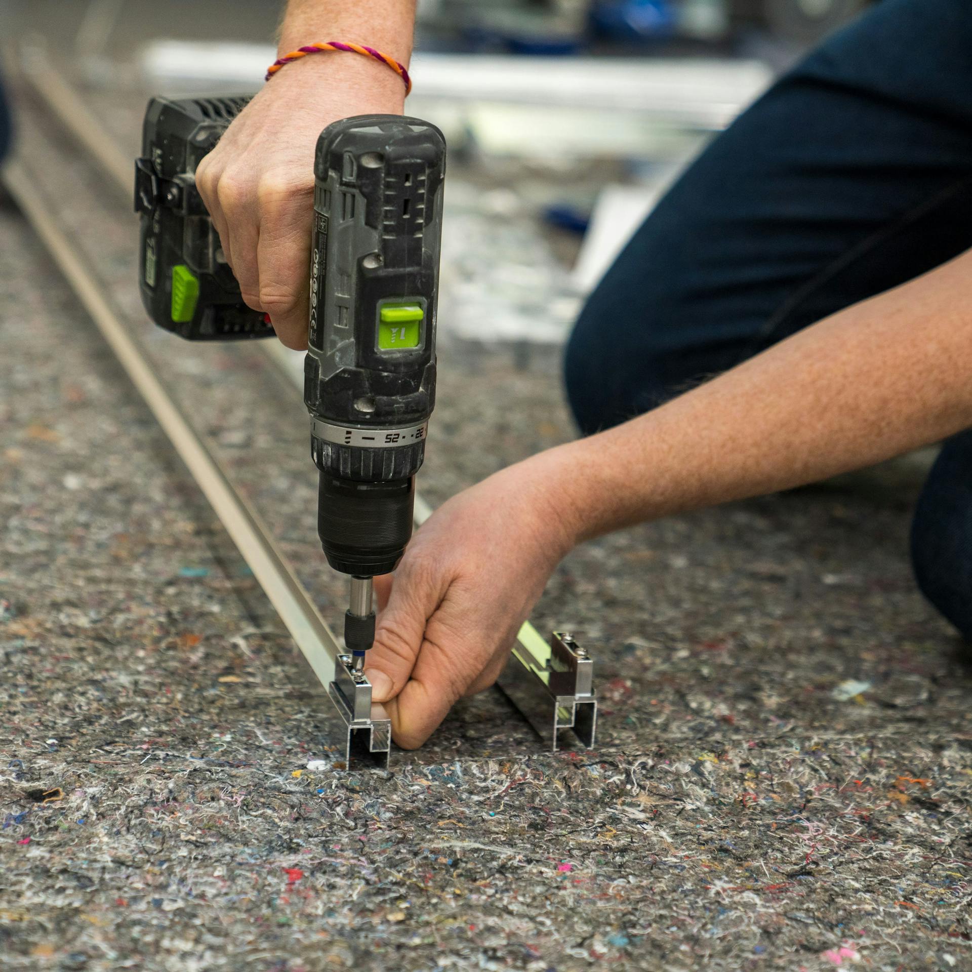 Handwerker bringt die Aufhänger für den Rahmen an.