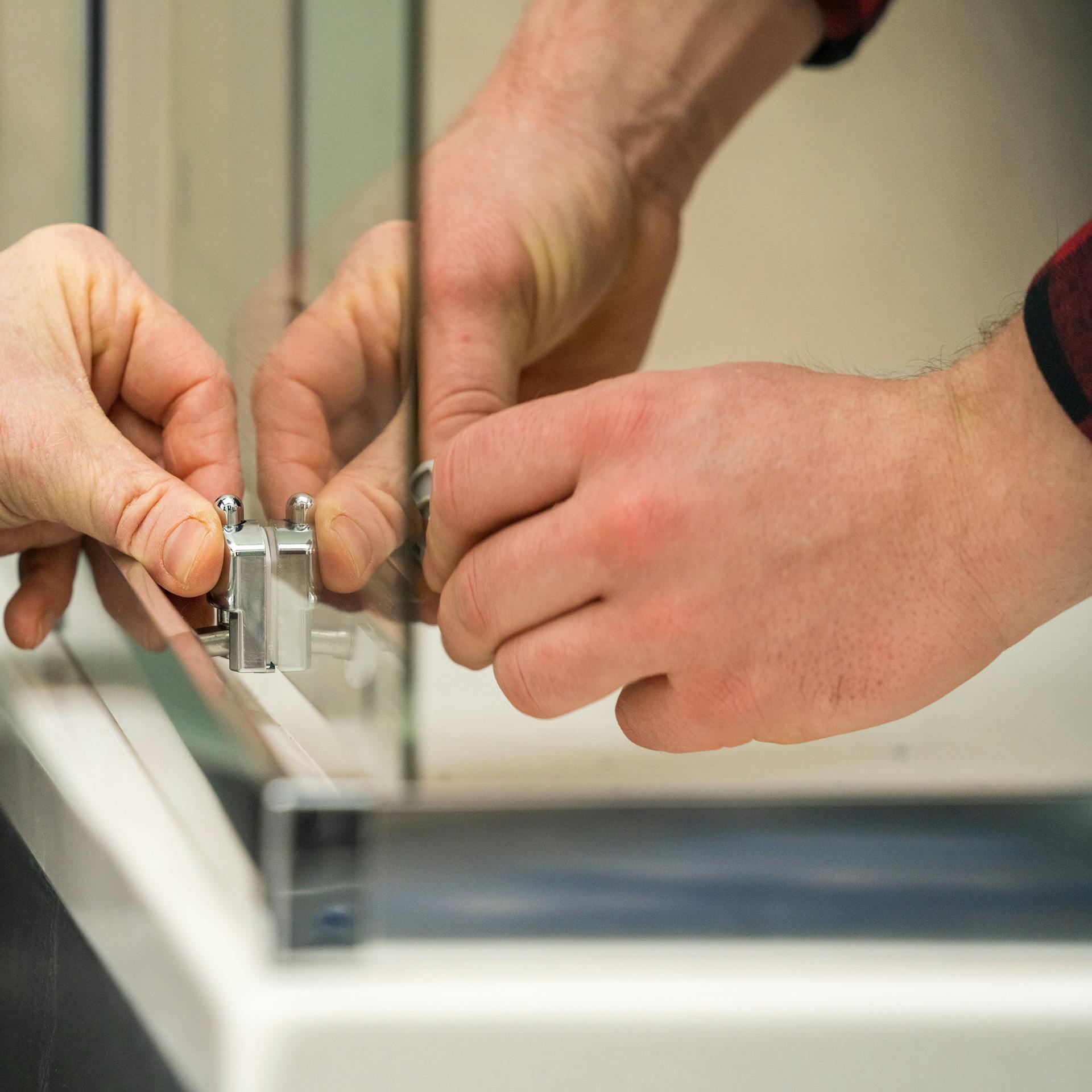 Heimwerker bringt Türstopper an Duschtür an.