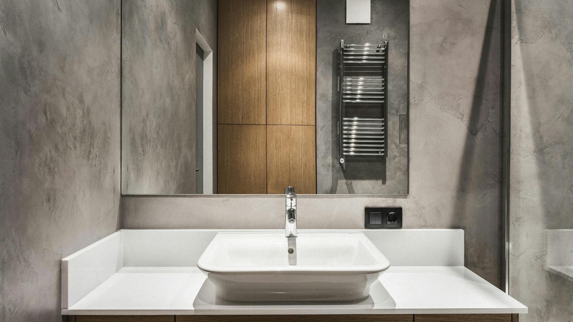 Fugenloses Badezimmer mit Waschbecken und Spiegel