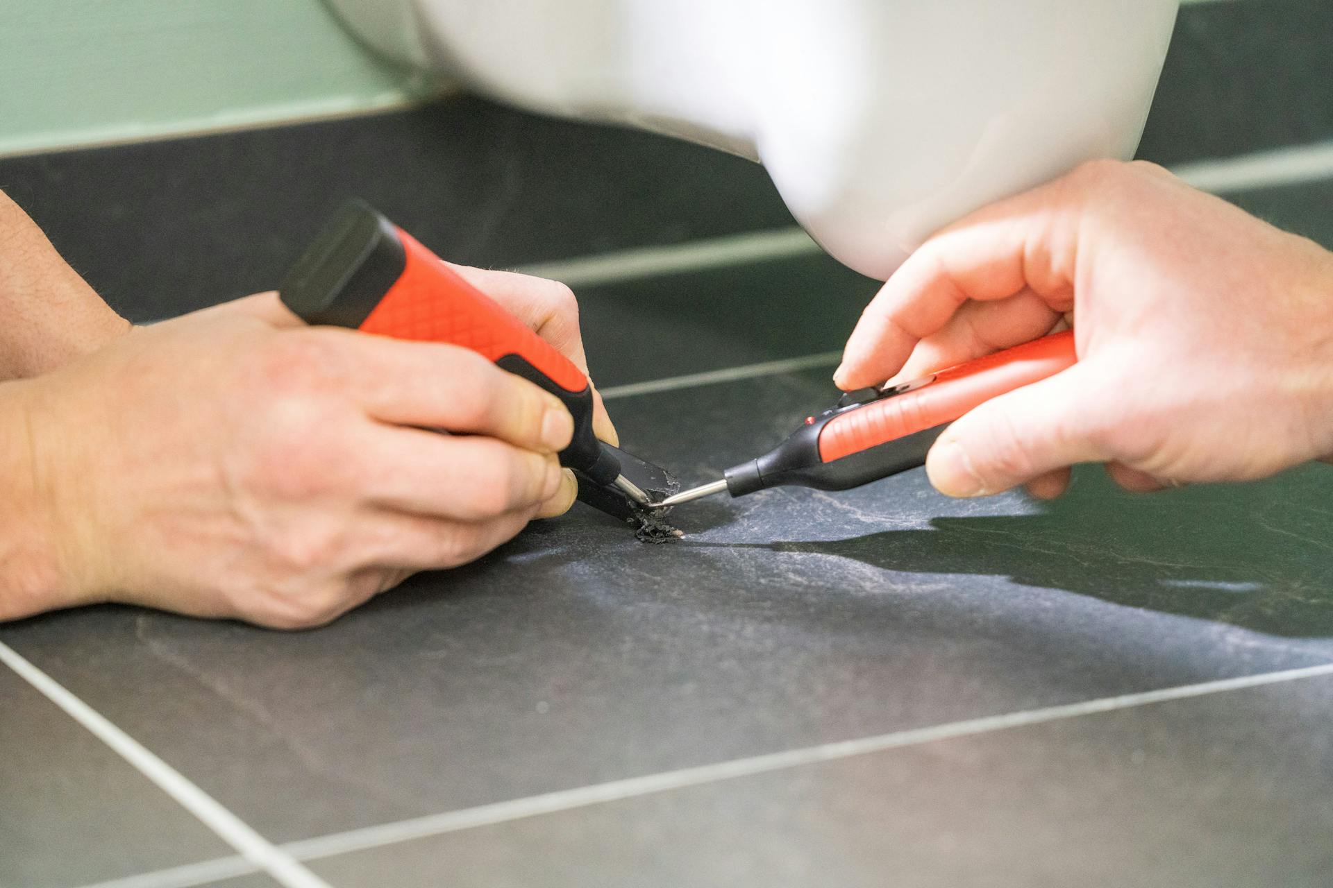 Gli appassionati del fai-da-te chiudono il foro con un blocchetto in cera fondente del kit di riparazione.