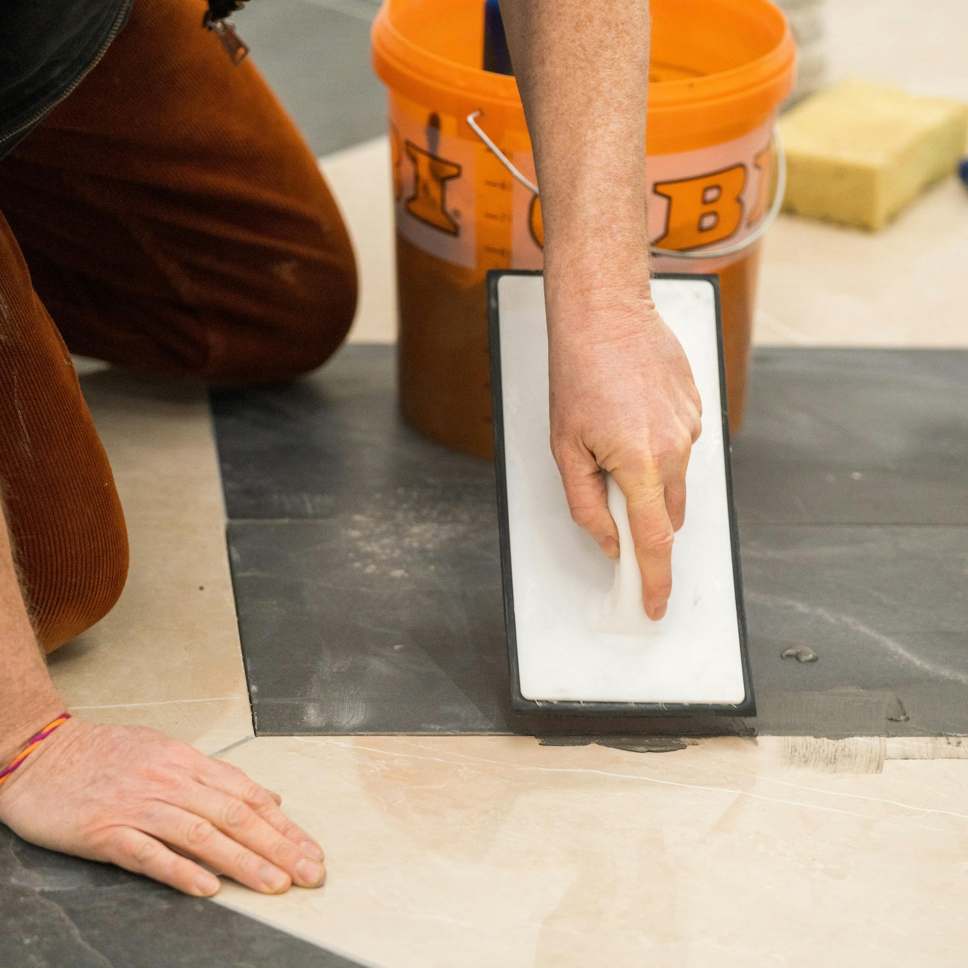 Jemand verfugt die neue Fliese.