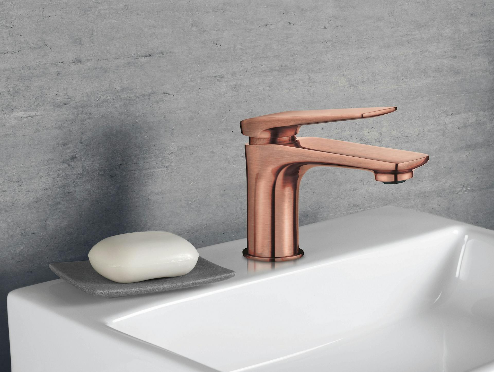 Waschbeckenarmatur in Kupfer vor grauer Wand