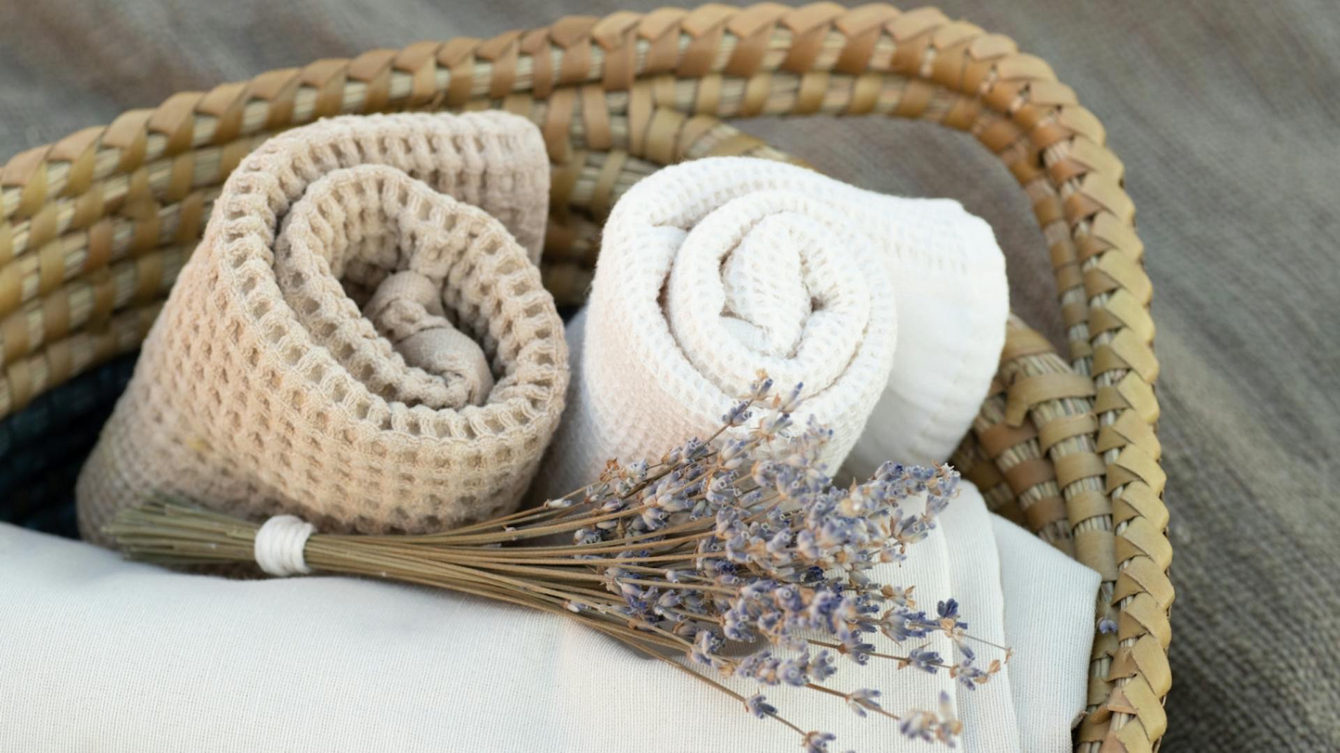 Geflochtener Korb mit aufgerollten Handtüchern.