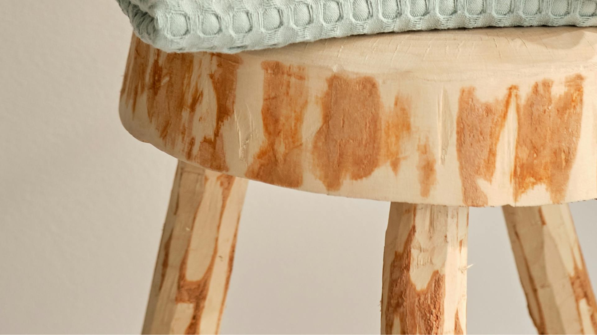 Holzhocker mit pastellfarbenen Handtüchern.