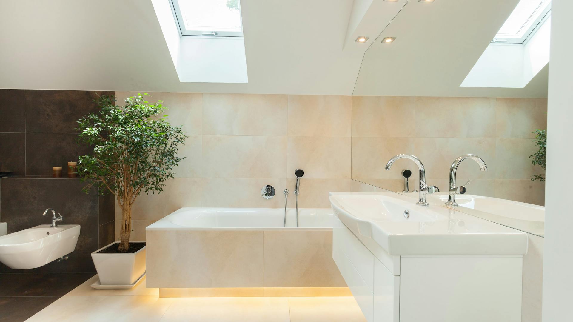 Badewanne mit indirekter Beleuchtung in cremefarbenem Bad.