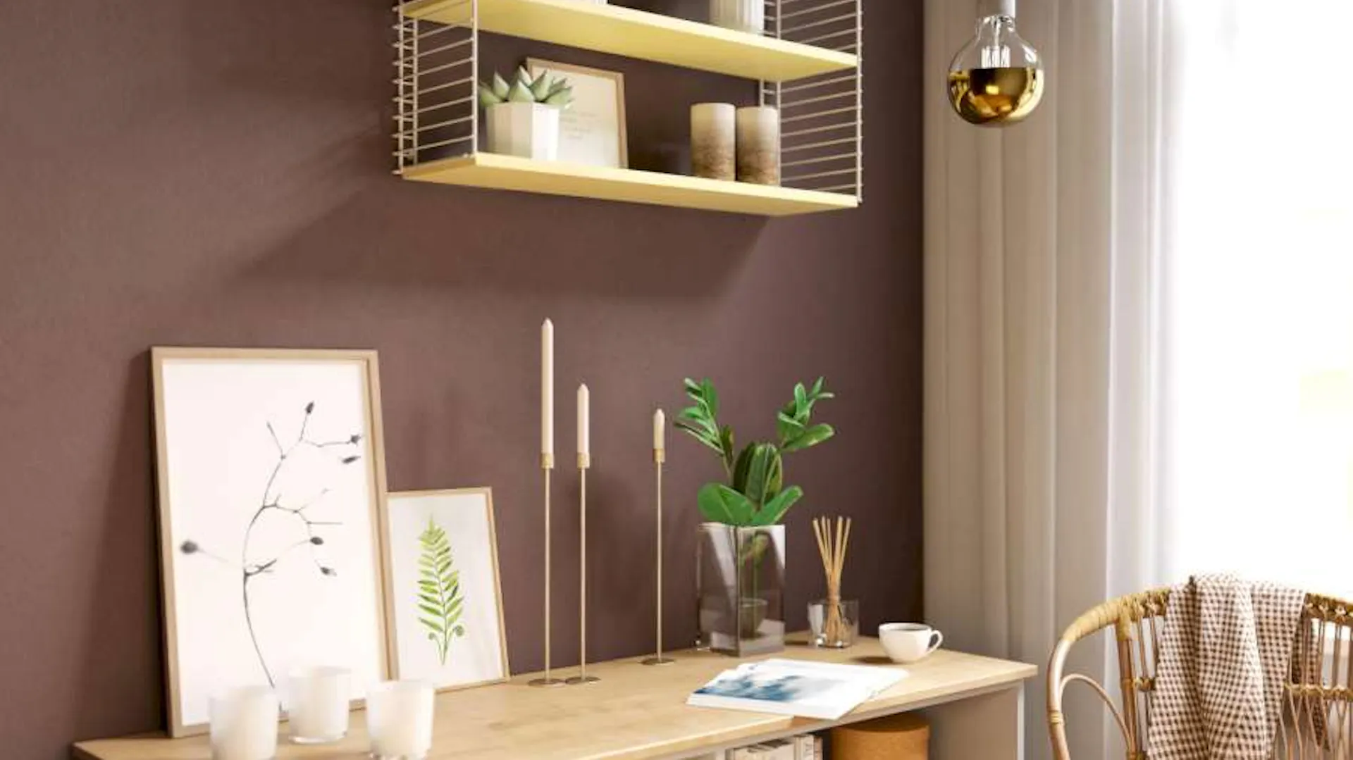 Eine rotbraune Wand, an derin Regal hängt. Darunter steht ein offenes Sideboard.