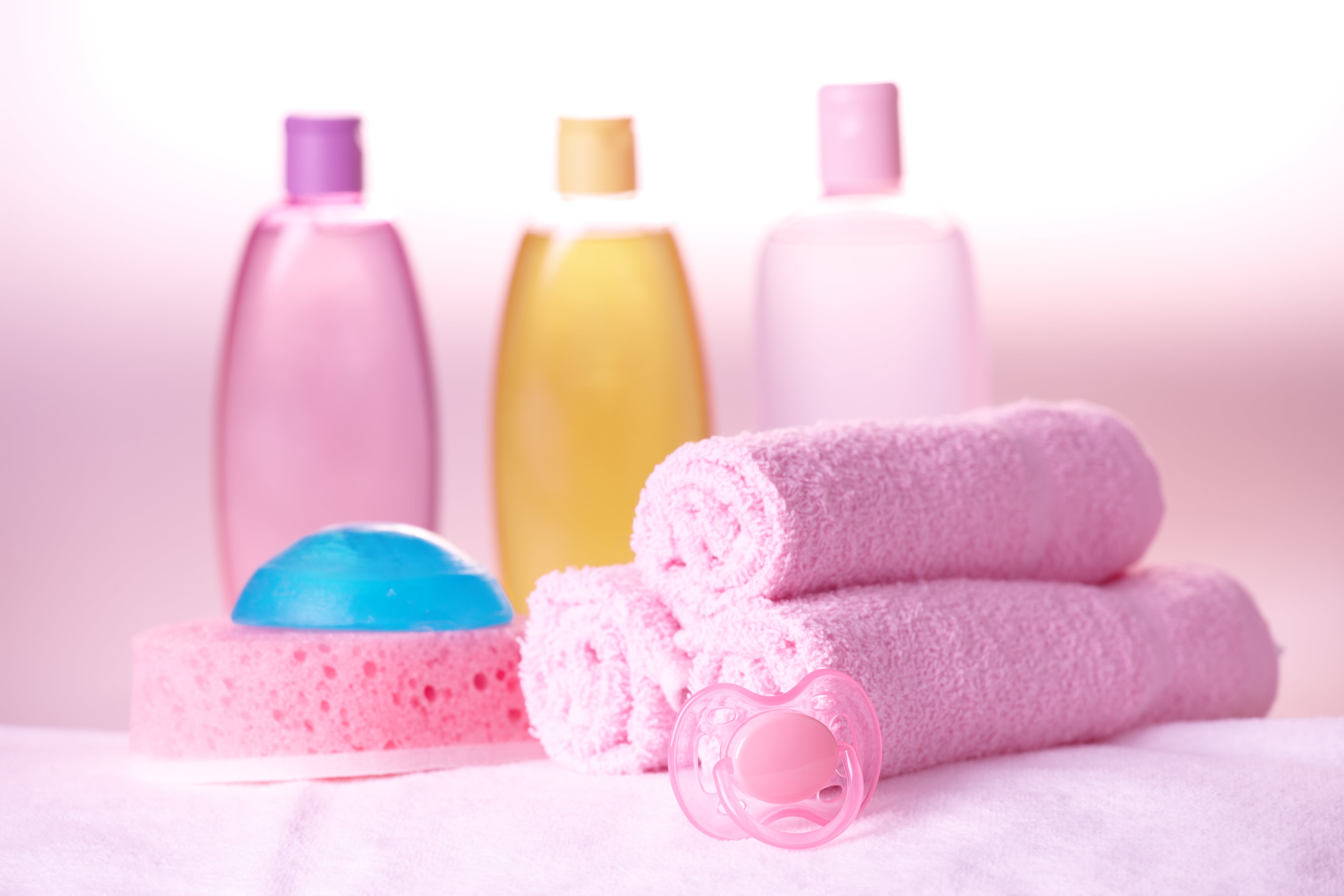 Asciugamani rosa e lozioni per bambini.