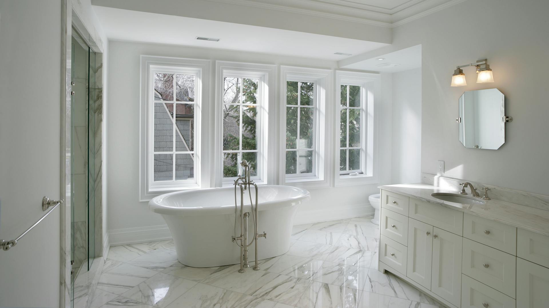 Kúpeľňa s dlažbou v mramorovom vzhľade v kombinácii s pochrómovanou batériou.