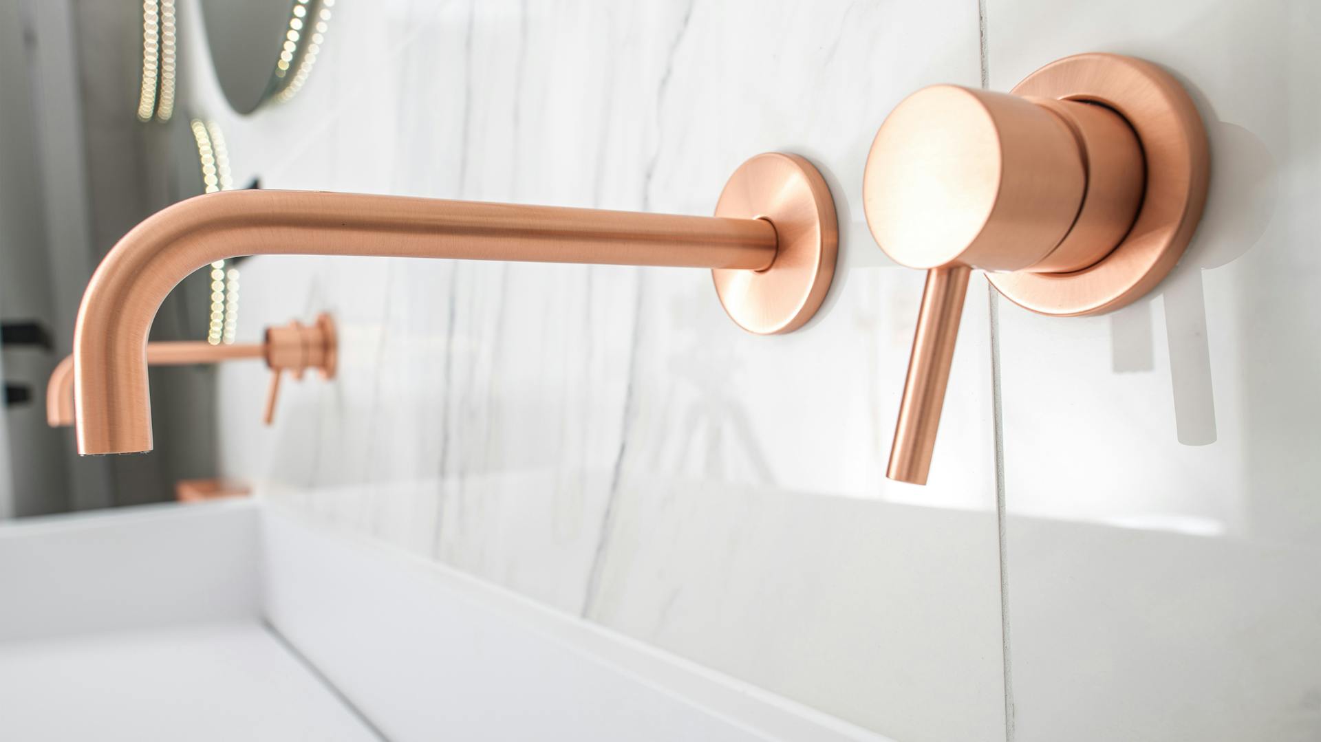 Obkladačky v mramorovom vzhľade a medená batéria.