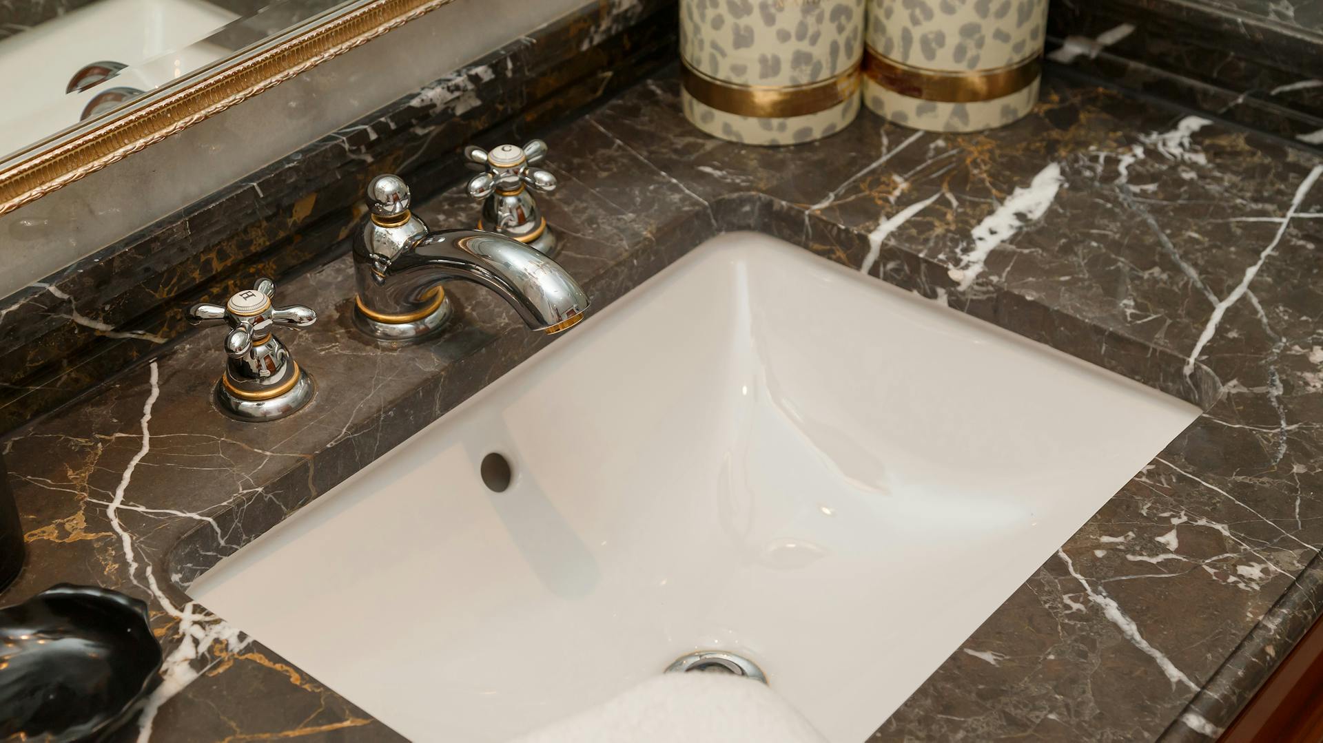 Čierna mramorová doska s bielym umývadlom.