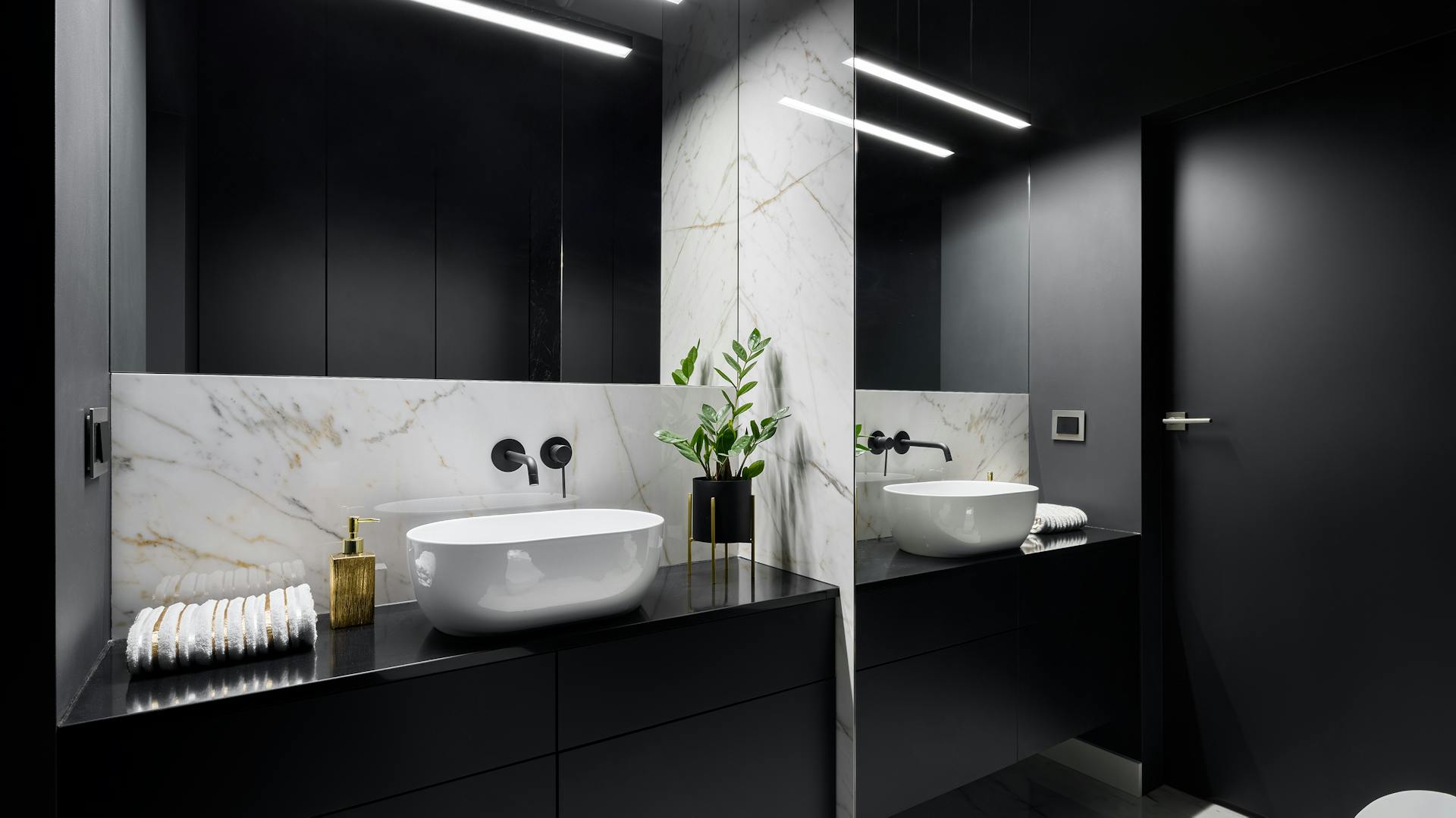 Kúpeľňa s čiernym nábytkom a mramorom.