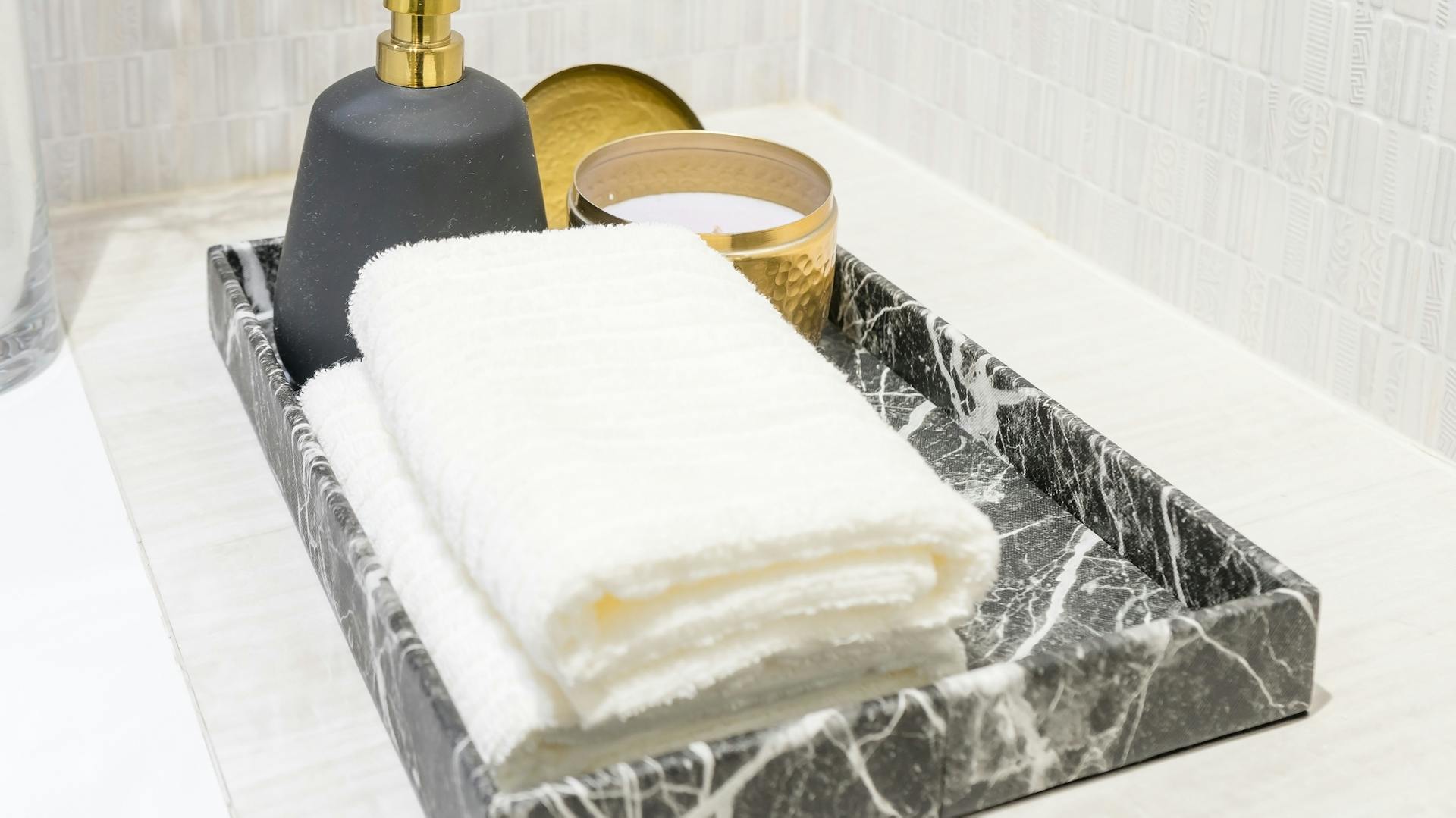 Mramorový podnos s uterákmi a dávkovačom mydla.