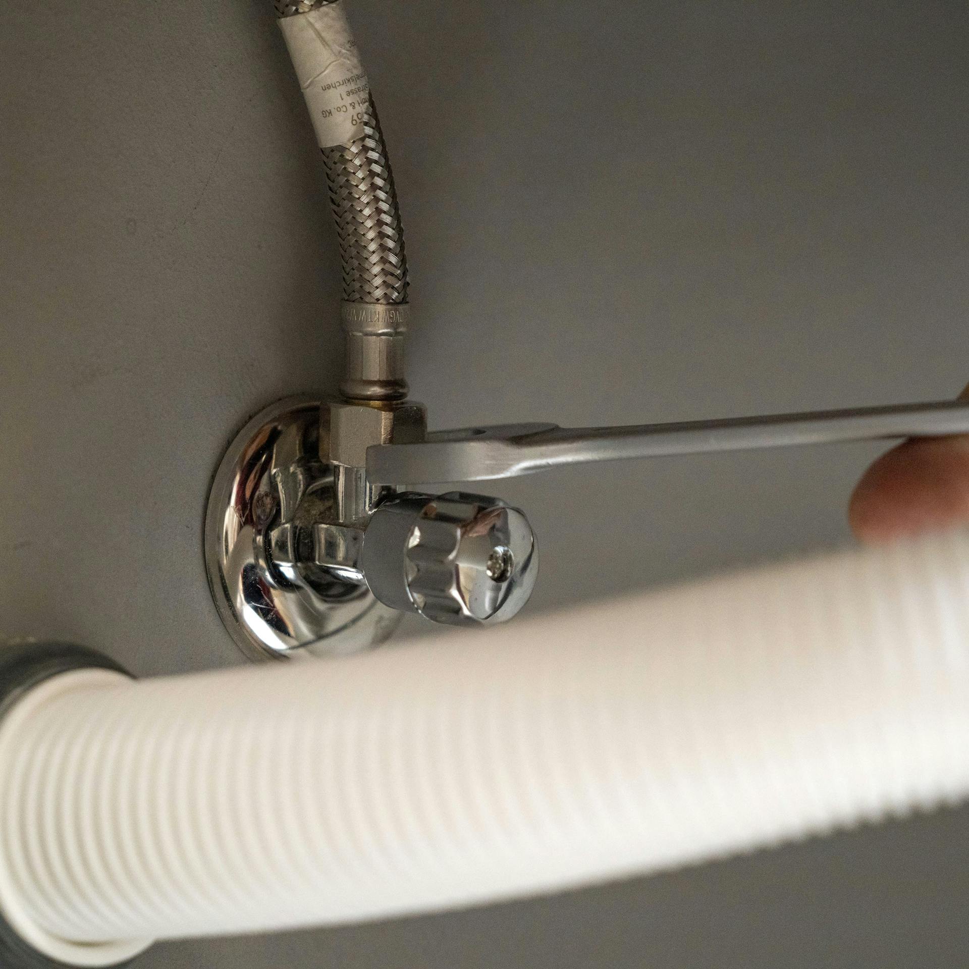 Heimwerker montiert neue Armatur.